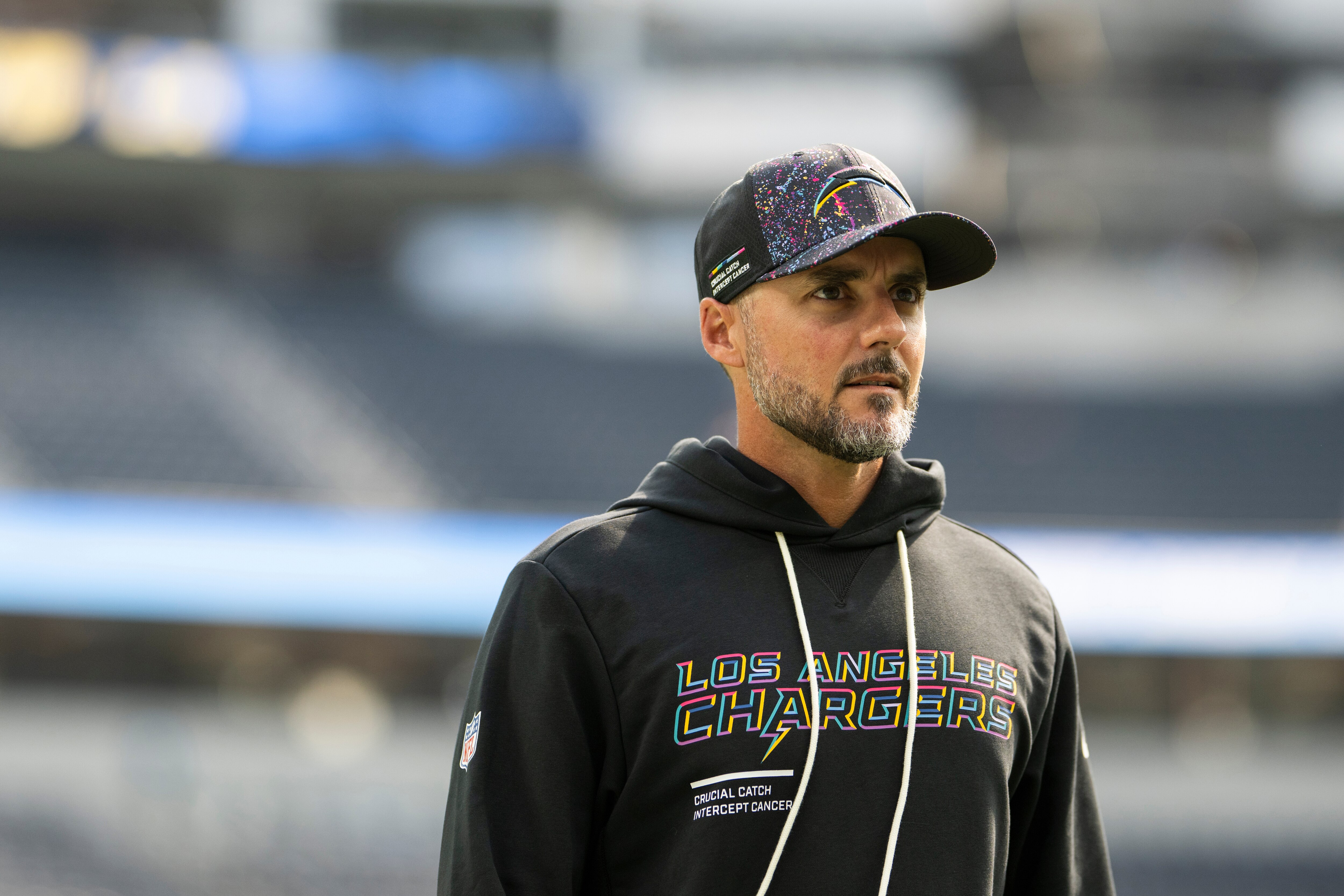 Los Angeles Chargers defensive coordinator Jesse Minter walks on the field before an NFL football game against the Washington Commanders, Sunday, Oct. 5, 2025, in Inglewood, Calif.