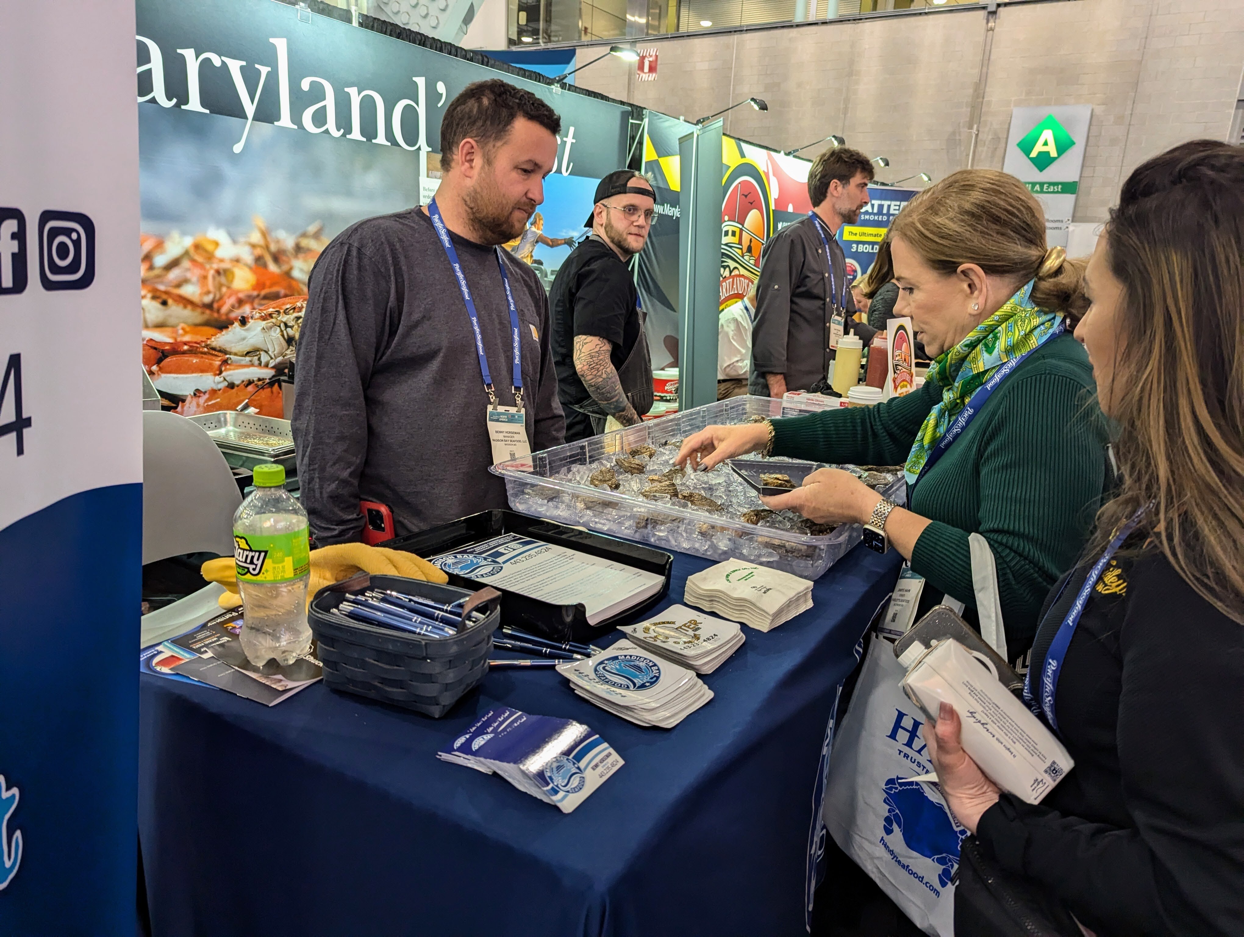Benny Horseman, co-owner of Madison Bay Seafoods, helps Faidley's co-owner Nancy Devine select six of his oysters on March 17, 2025 for a test of packing machinery at the Seafood Expo North America. She carries his oysters and crabs as part of her company's commitment to Chesapeake Bay seafood.