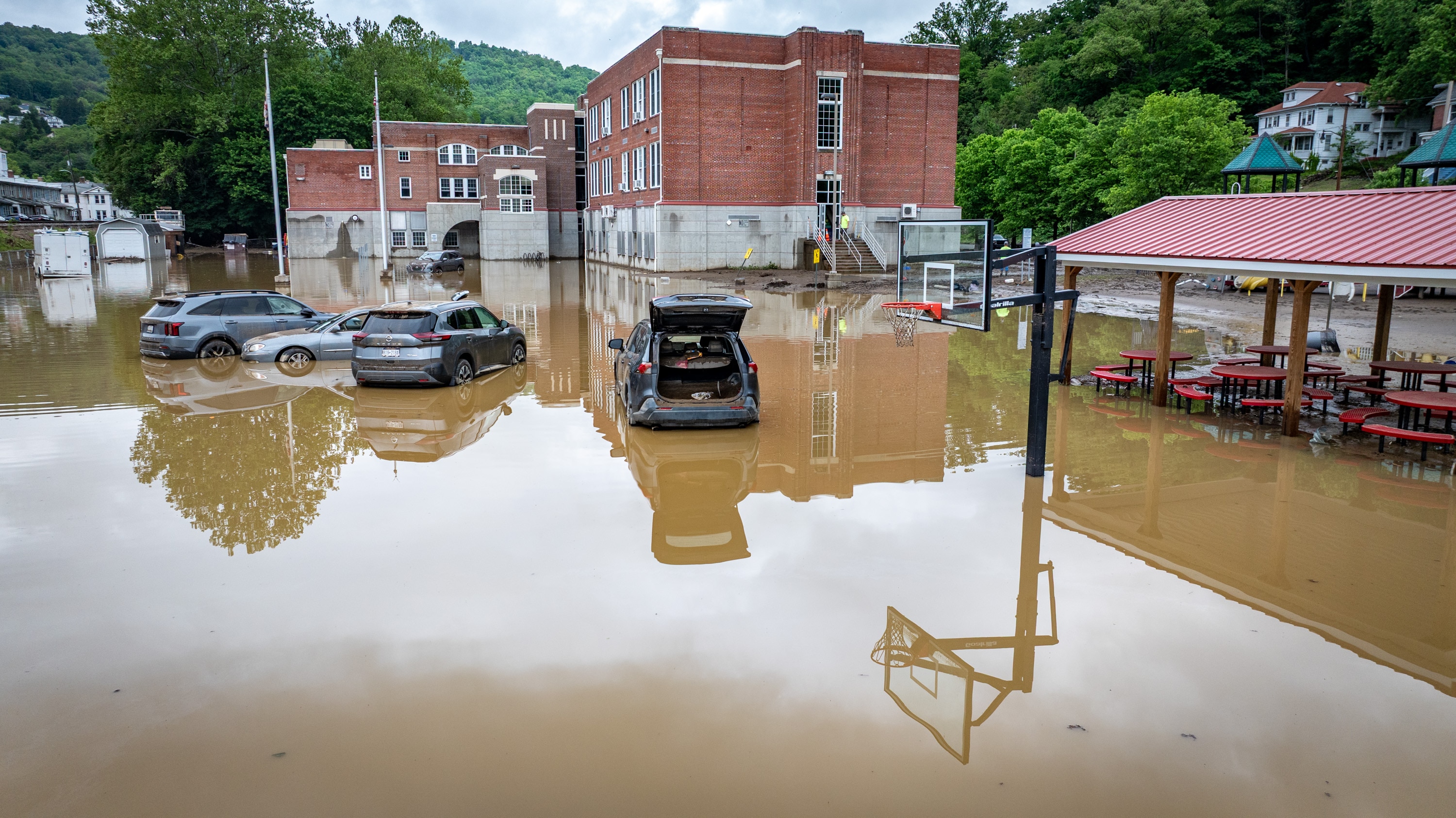 Waterlogged cars sit in the flooded parking lot of Westernport Elementary School on Thursday, May 15, 2025, after a catastrophic storm hit the area on Tuesday.