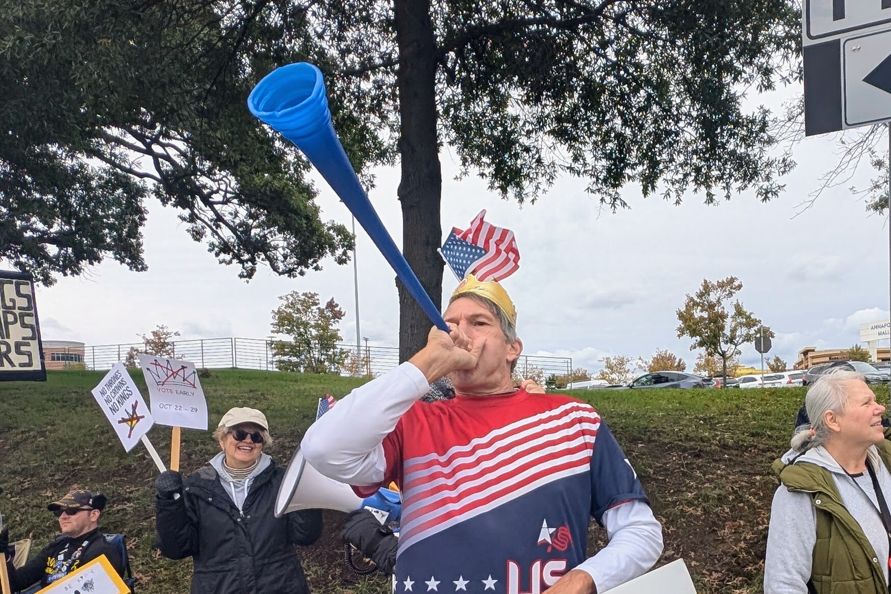 Paul Flack blows his vuvuzela at the Annapolis No Kings rally on Saturday, dressed in American flag colors and topped with a golden Burger King crown. About 600 people turned out for the final rally before Election Day.