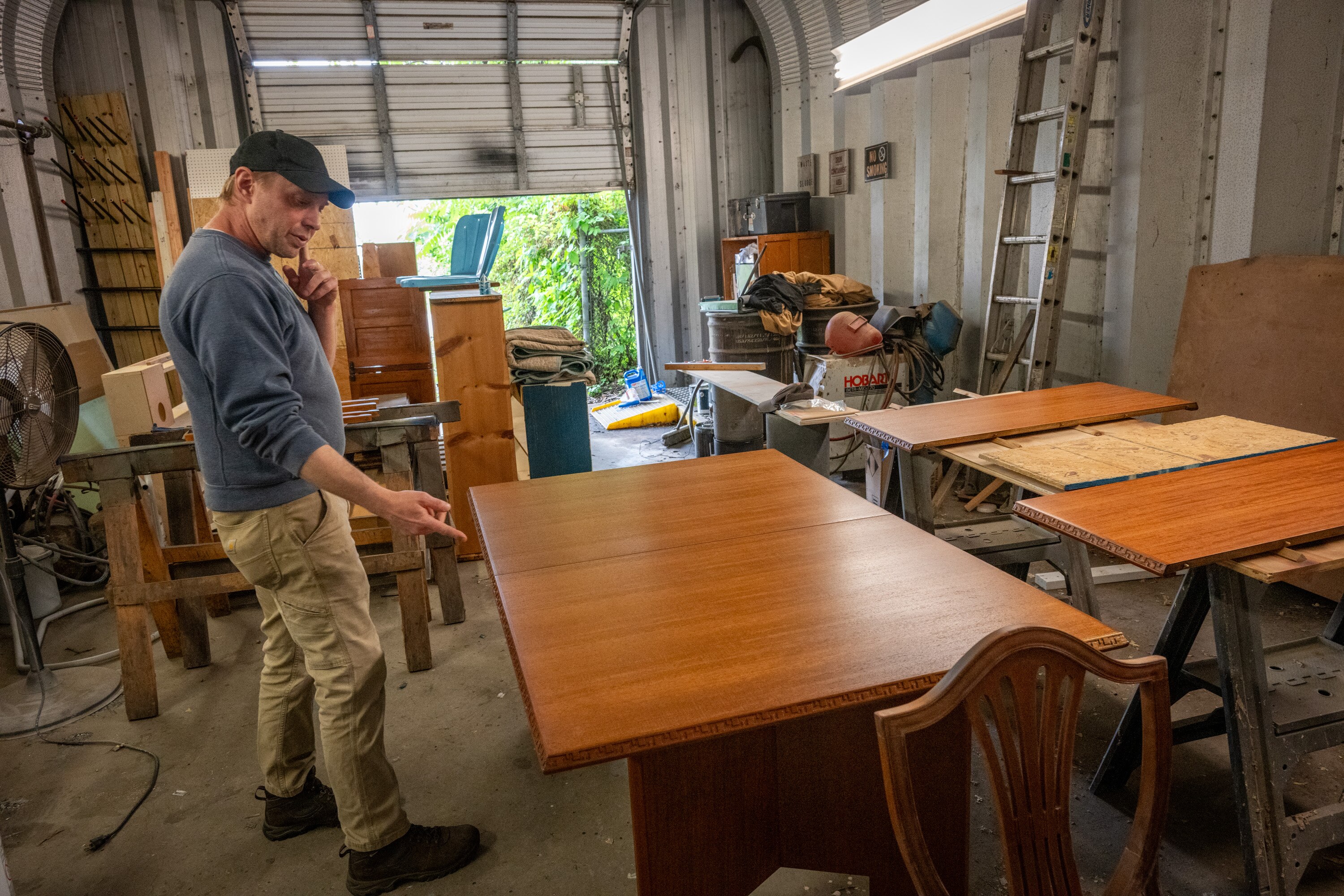 Nick Petr, co-owner of Baltimore Finishing Works, looks at a Frank Lloyd Wright table brought in for refinishing.