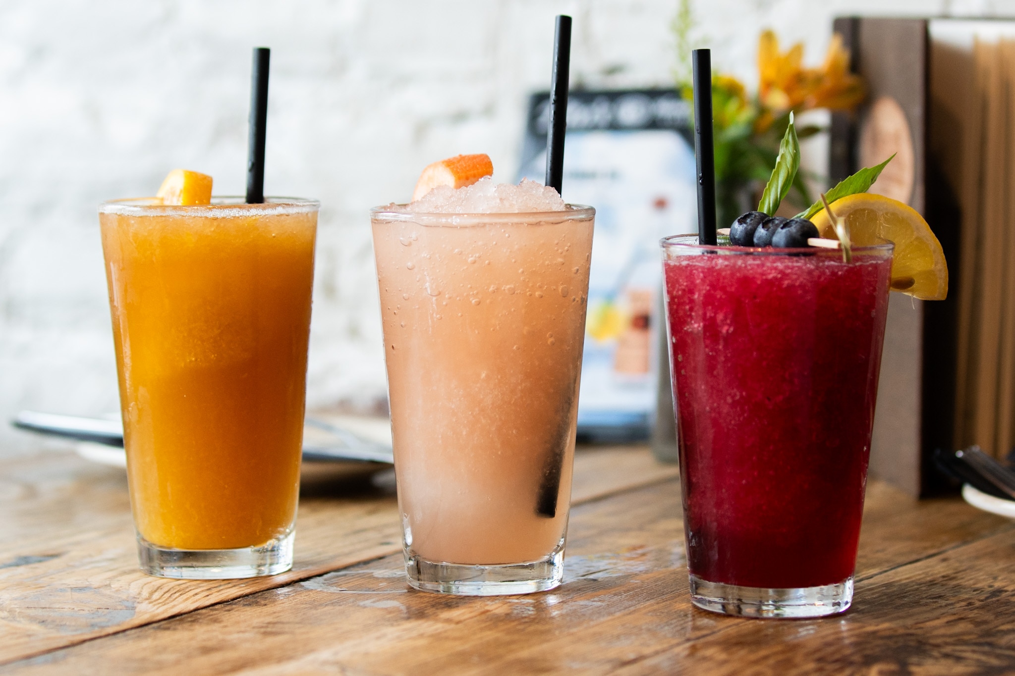 The passionfruit tea crush (left), traditional crush, and lemon basil blueberry crush (right) are photographed at Wicked Sisters on July 18, 2024.