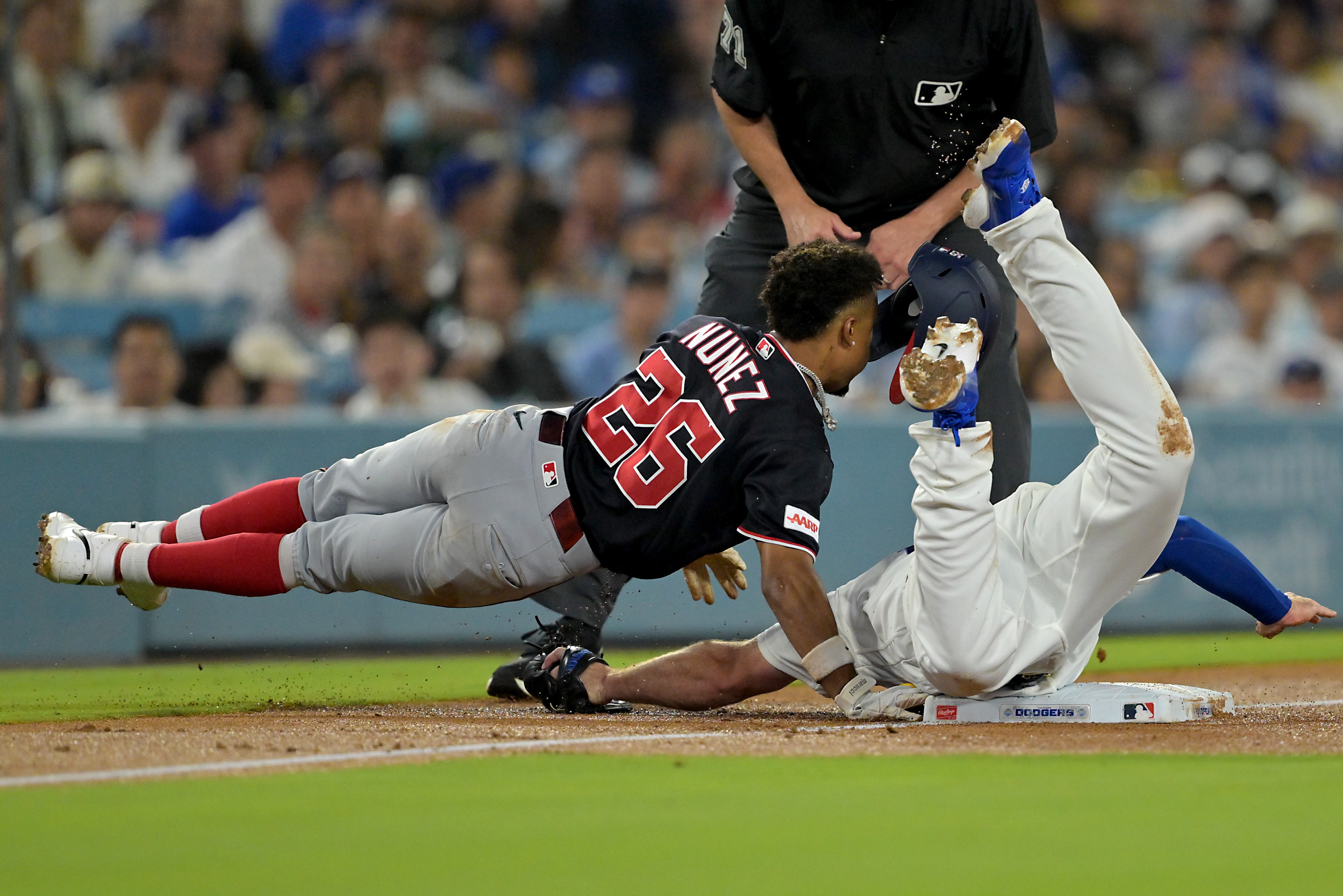 Nasim Nuñez is tagged out by Dodgers third baseman Max Muncy after oversliding the base during the third inning.