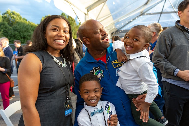 From left: Sade Newson, 32, Noah Newson, 6, Leland Melvin, 58, Aden Newson, 3, pose for a quick photo after opening remarks at the DART Impact Event held at the Johns Hopkins Applied Physics Lab, in Laurel, MD. Noah, an aspiring scientist, is shy meeting Leland Melvin the engineer, and retired NASA astronaut.