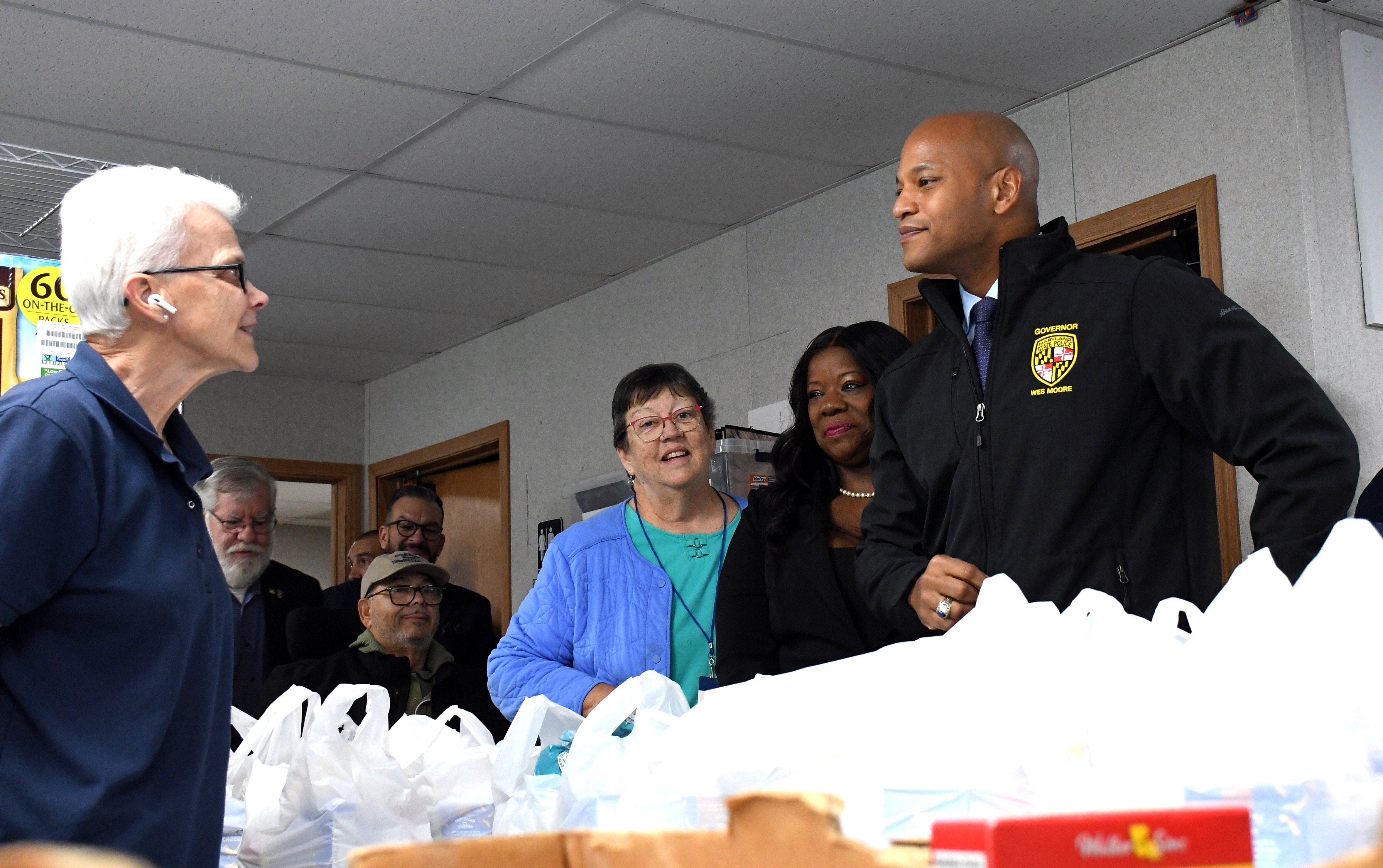 Maryland Gov. Wes Moore, left, talks with Bowie Food Pantry volunteer Janice Stritzinger, at left, on Friday, Oct. 24, 2025. In the center are pantry volunteer and treasurer Lorri Meadows and Prince George's County Executive Aisha Braveboy.