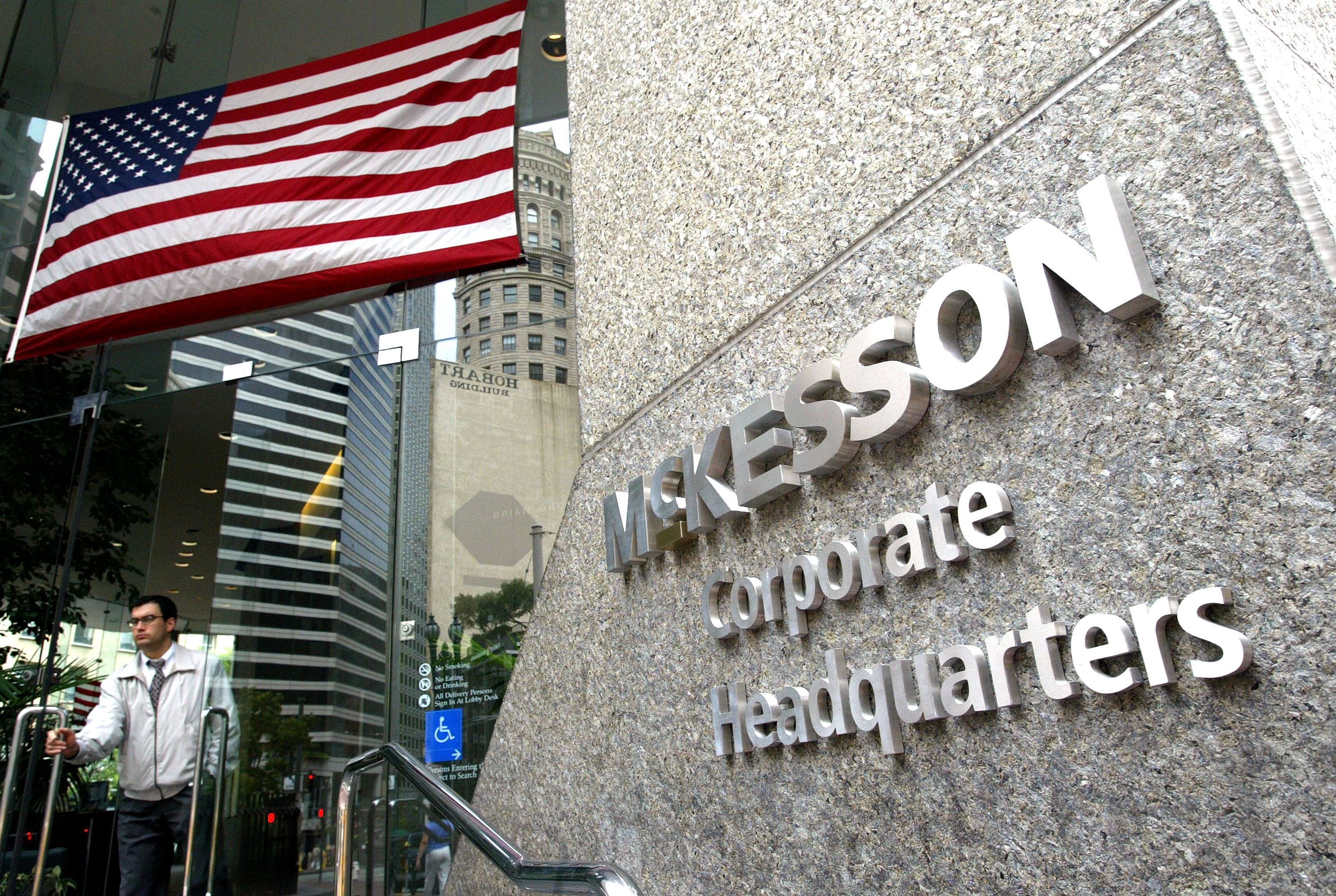 Silver metal letters on a stone column read McKesson corporate headquarters. An American flag hangs in the upper left corner.