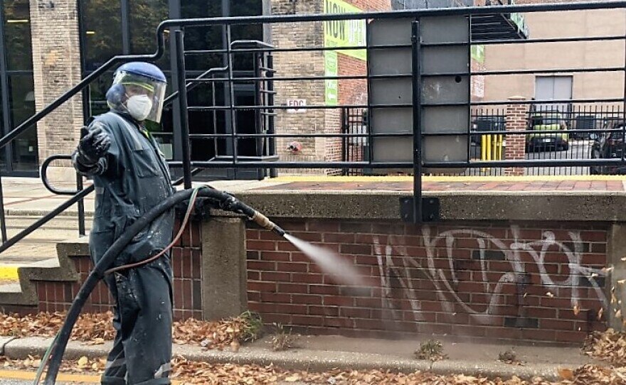 Eric Ford uses a Dustless Blaster to remove spray paint from a Light Rail stop on Howard Street.