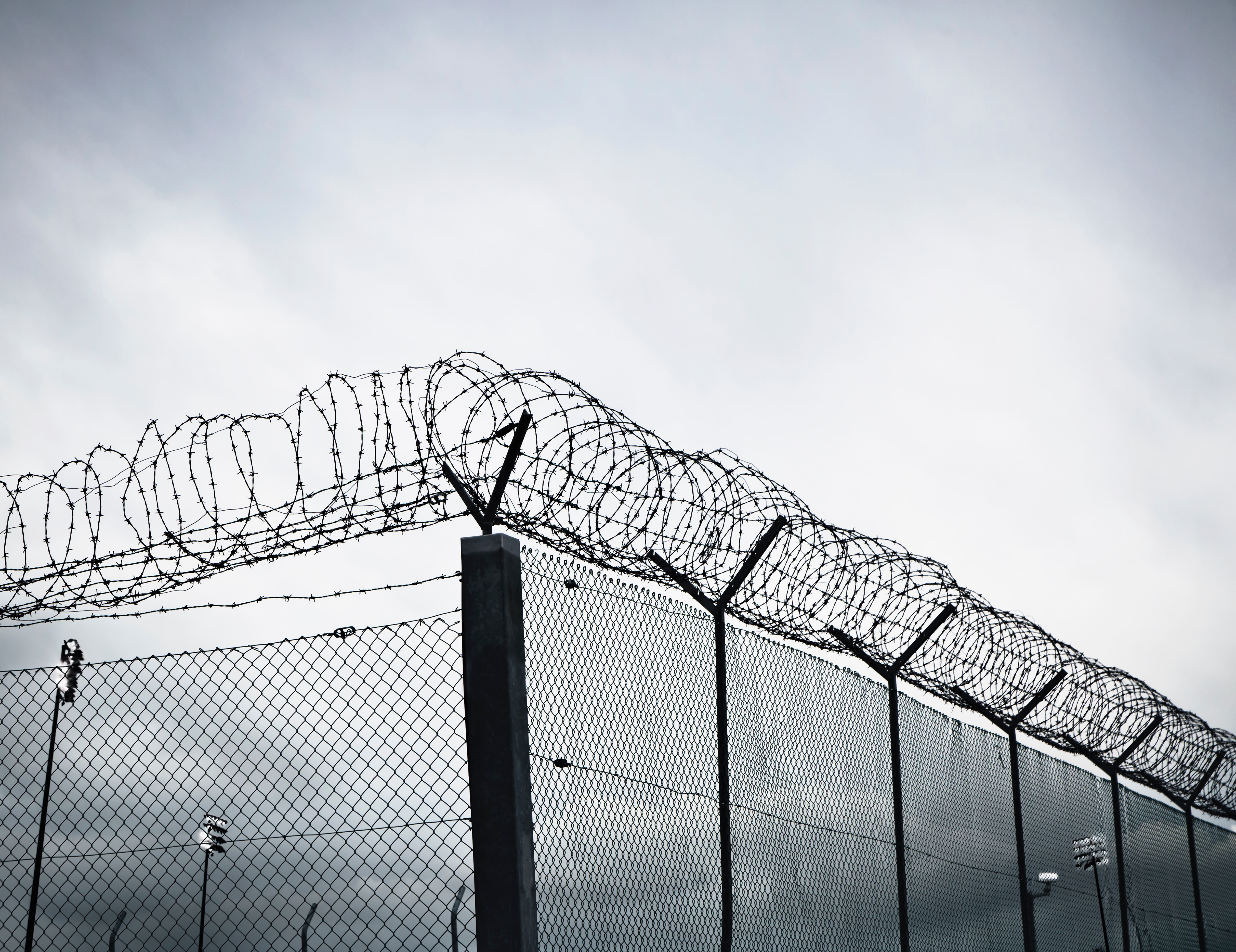 Chain link fence with barbed wire and razor wire.