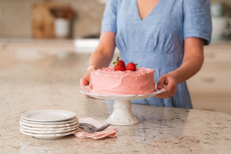 Sally McKenney stands alongside a finished strawberry cake. The recipe is featured in her bestselling cookbook, "Sally's Baking 101."