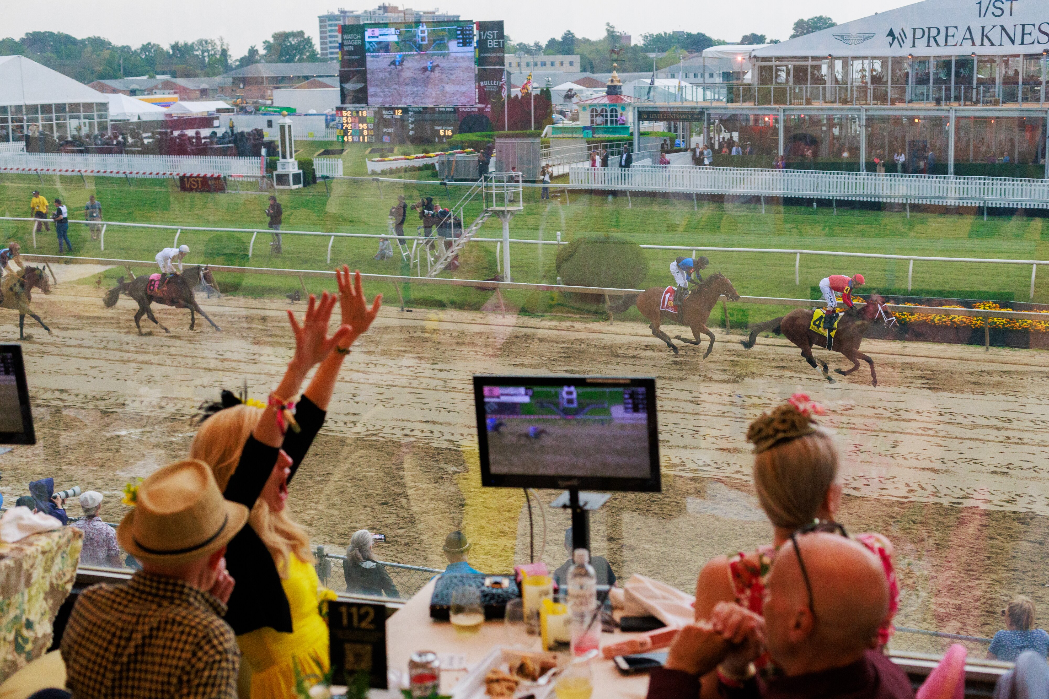 Spectators take in a race on Preakness Friday at Pimlico Race Course.