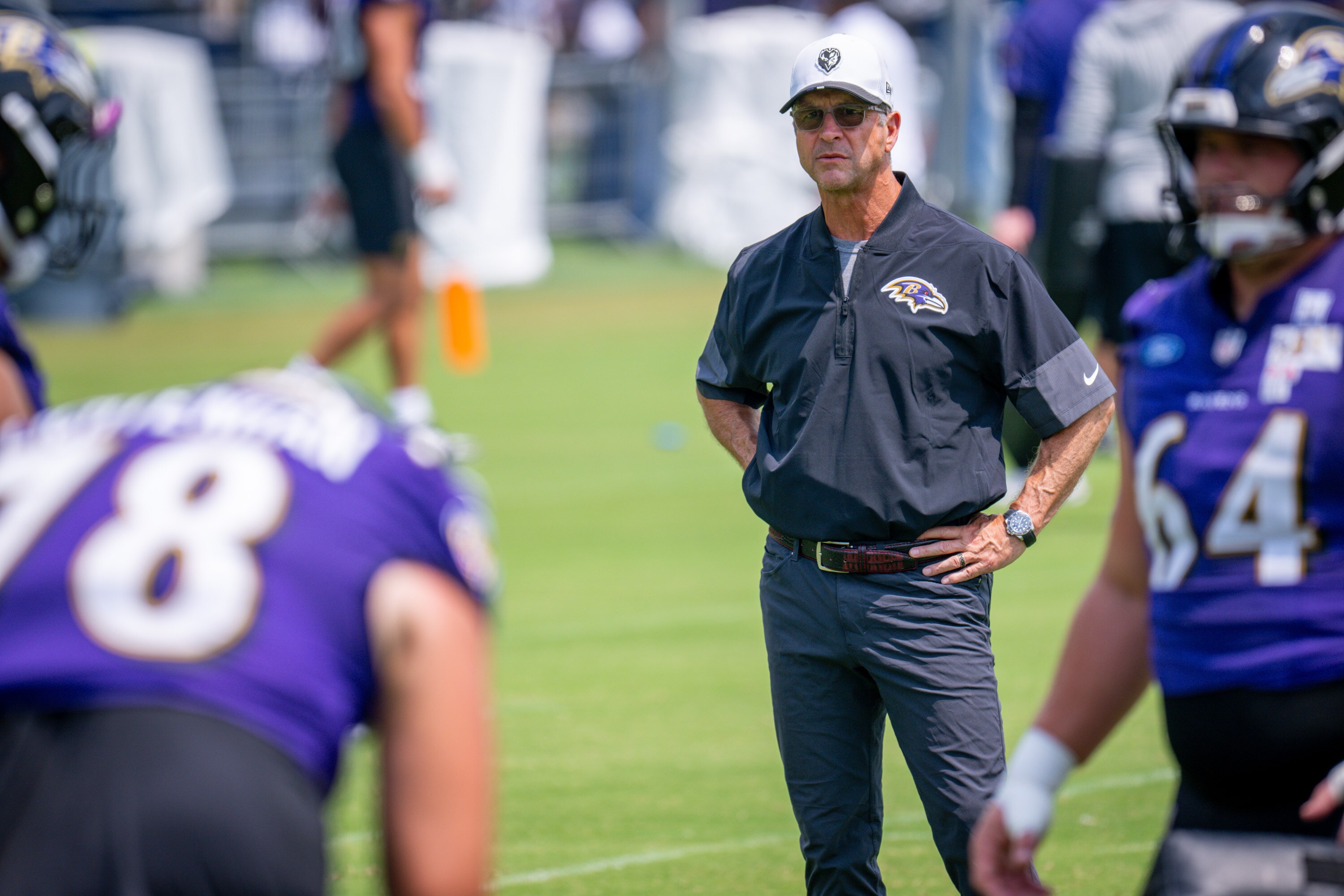 Ravens coach John Harbaugh watches the defensive line run through drills during Ravens training camp