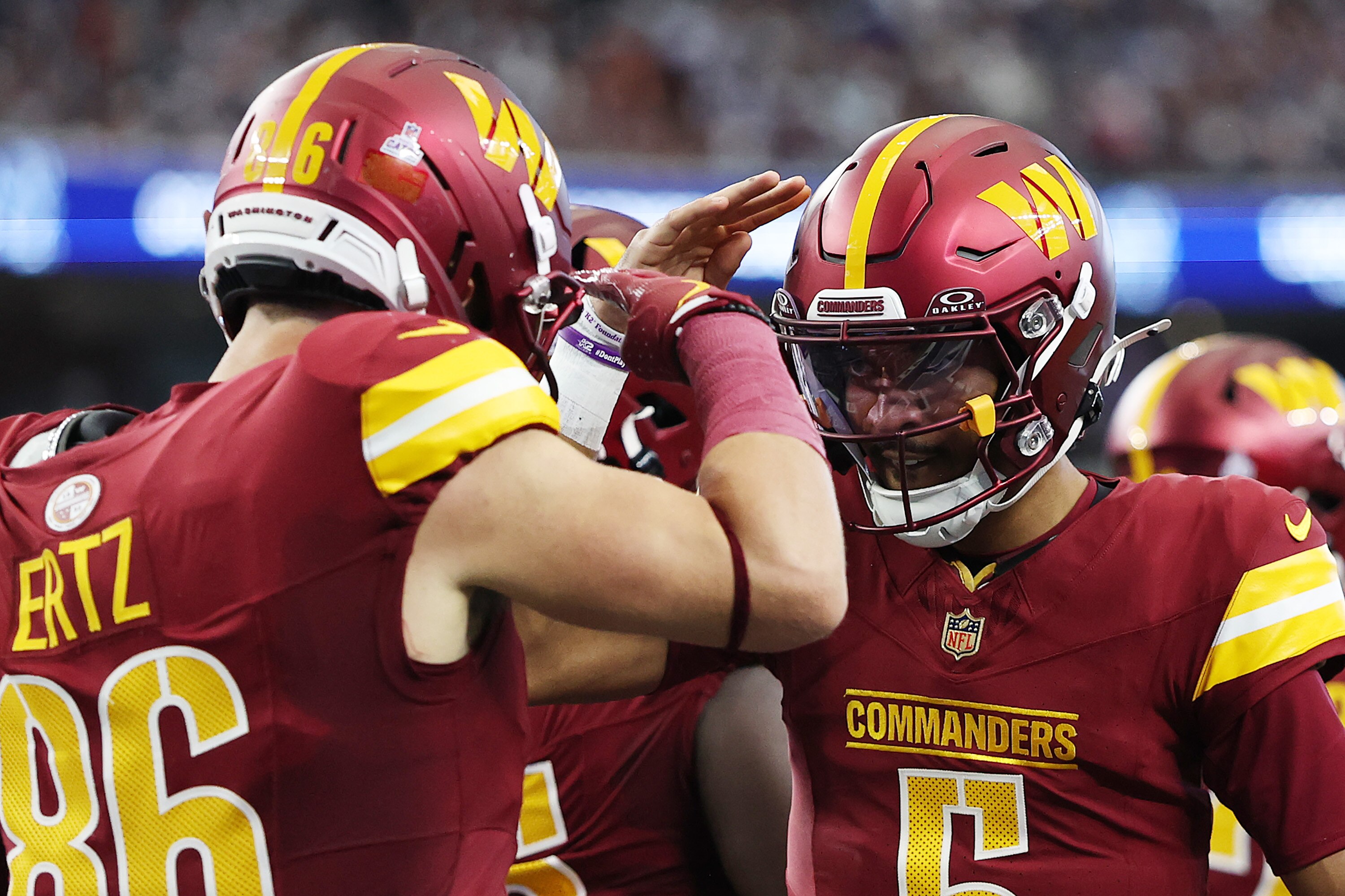 Zach Ertz and Jayden Daniels salute each other after Ertz’s receiving touchdown in the first quarter.