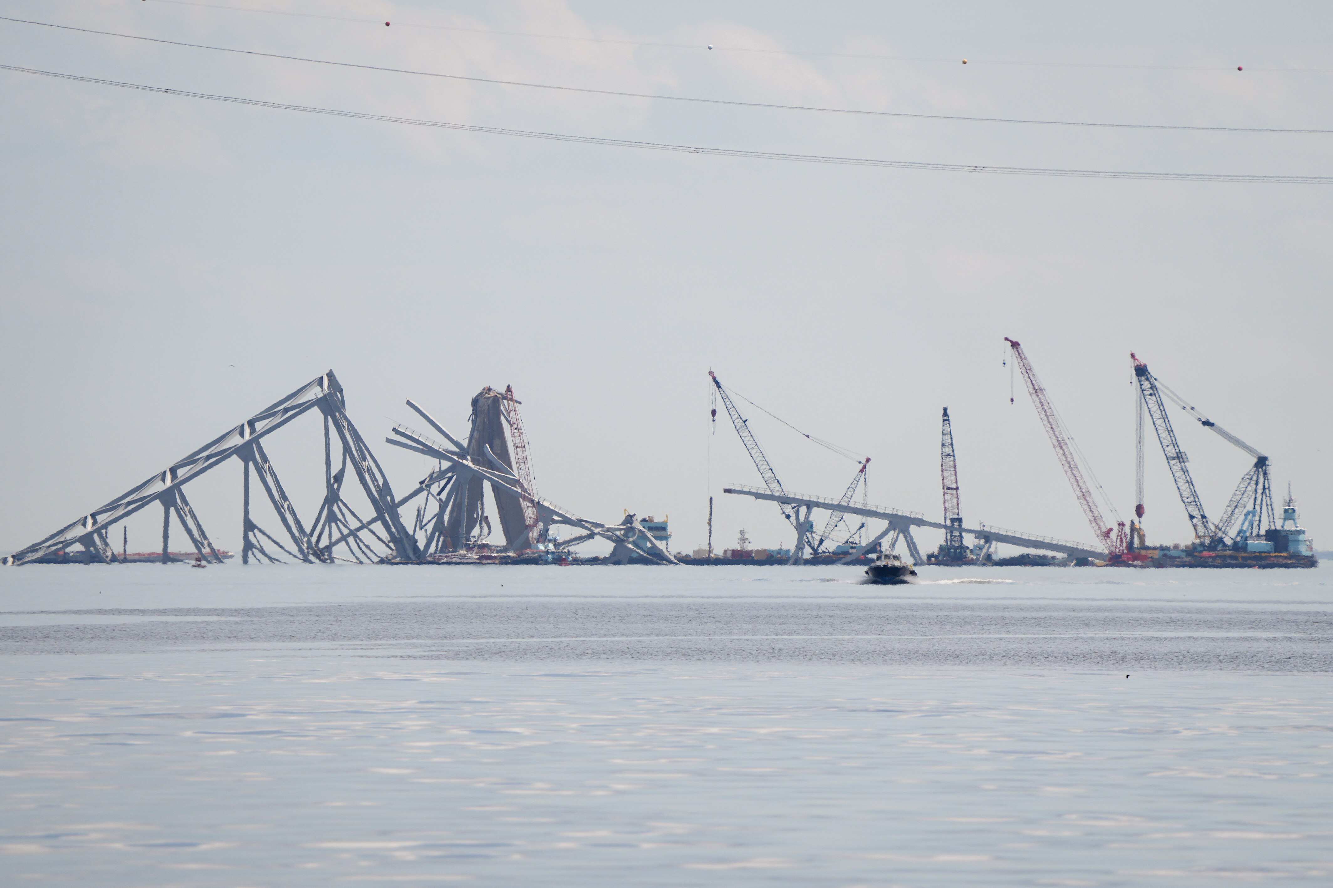 Remnants of the collapsed Francis Scott Key Bridge are lifted up by cranes, seen from a Department of Natural Resources boat on the Patapsco River in Baltimore, on April 10, 2024.