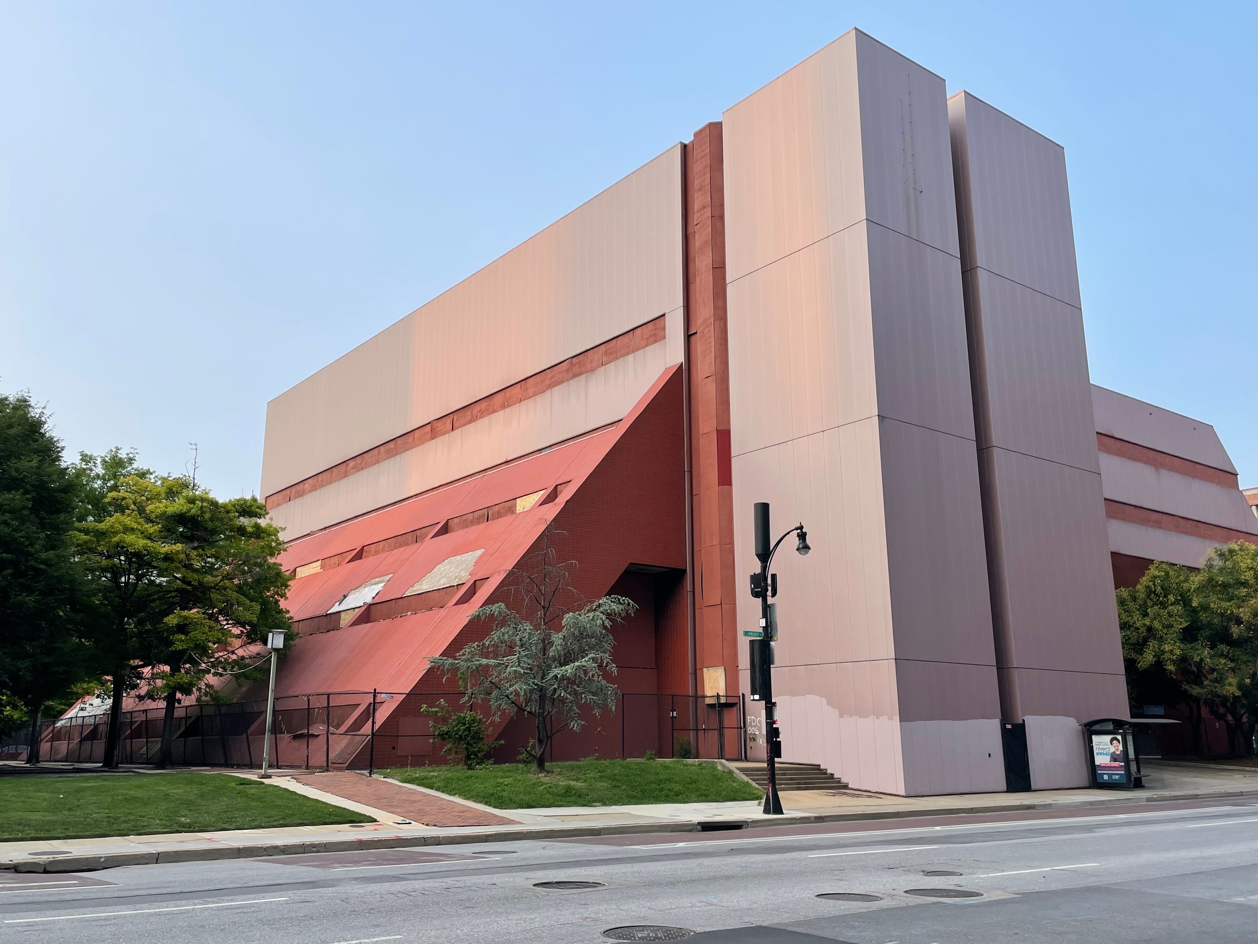 A masonry building is surrounded by black fencing.