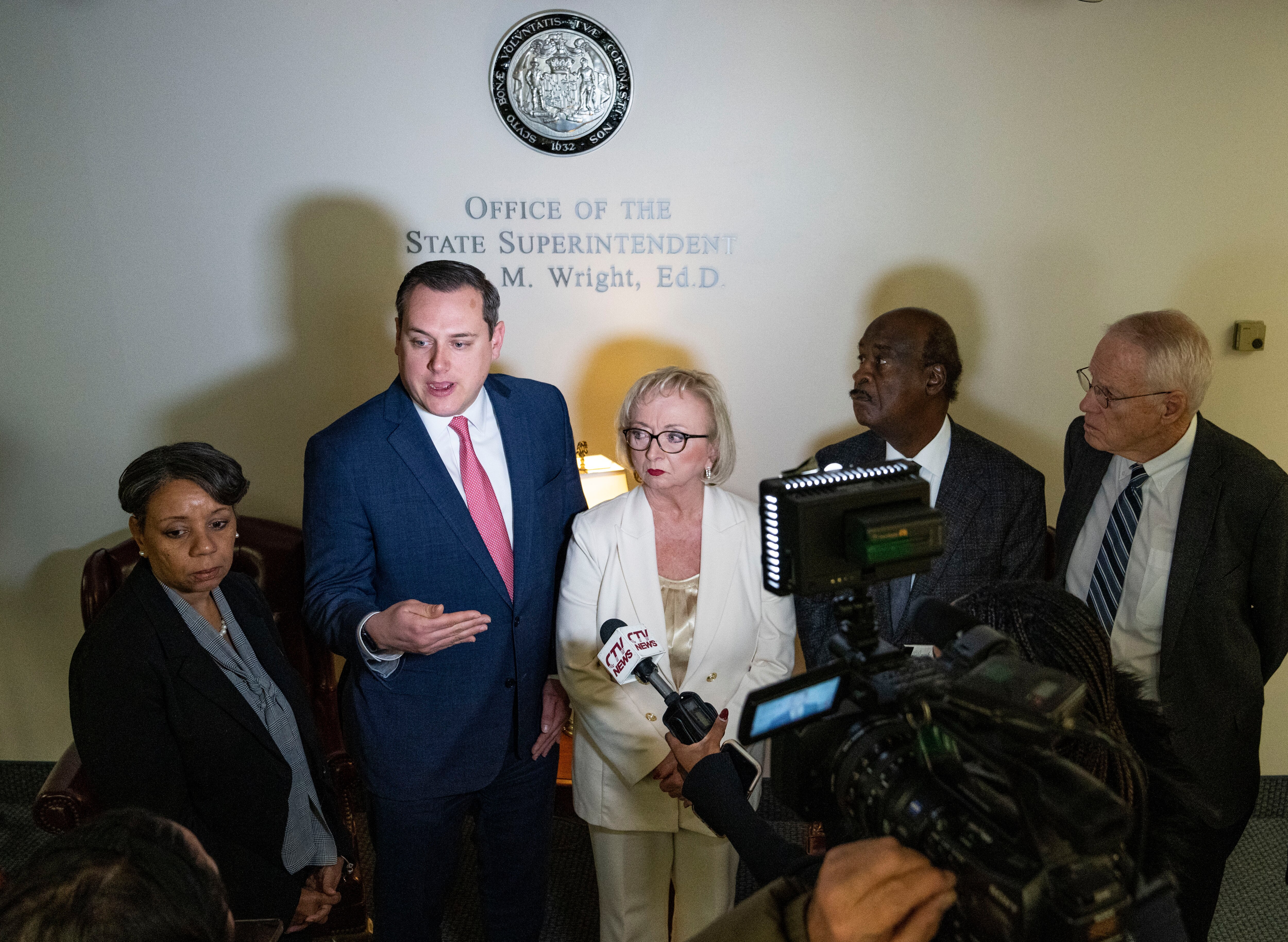 State Superintendent Carey Wright and school school board president Josh Michael, center, at a press conference earlier this year.