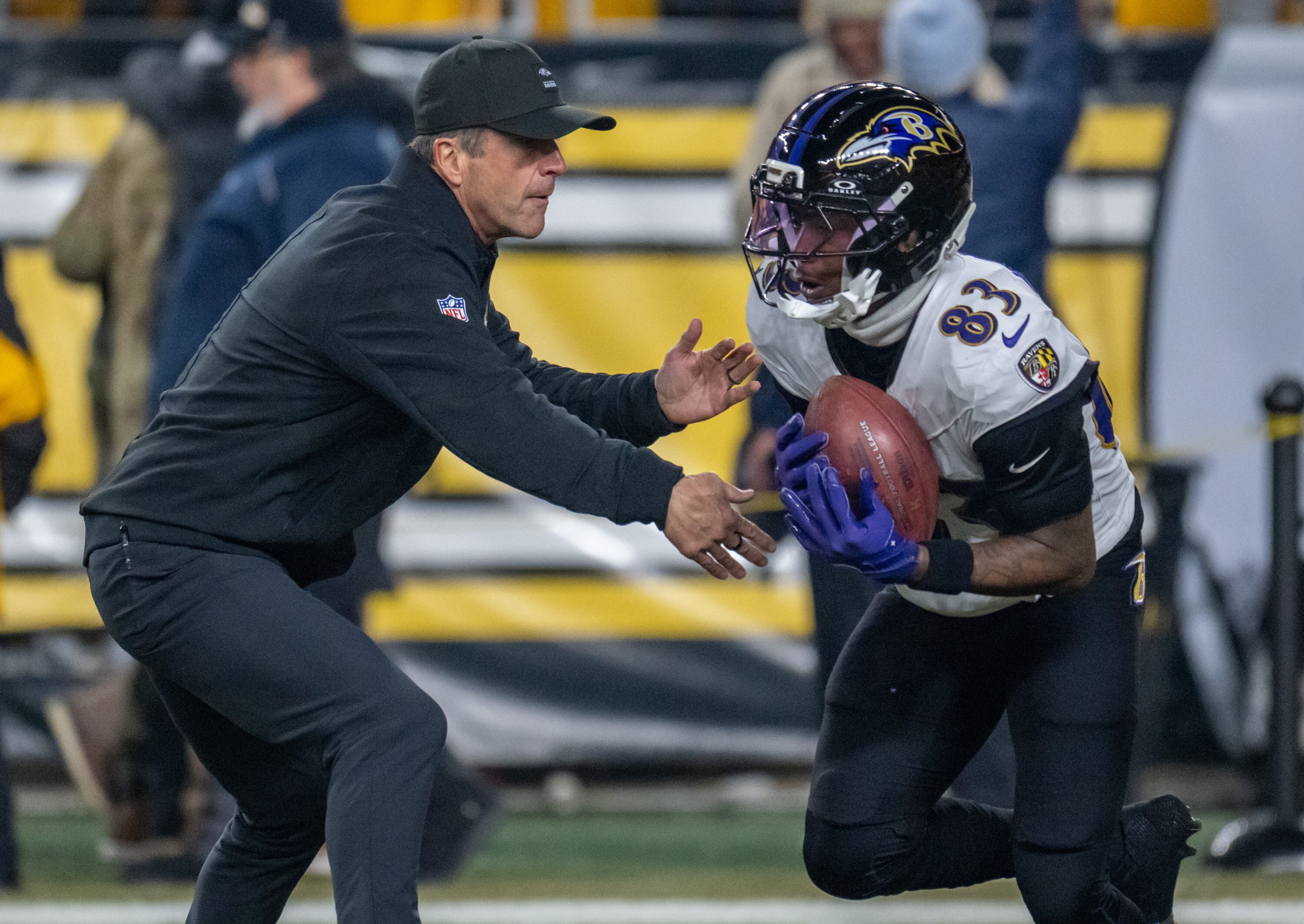 Ravens head coach John Harbaugh warms up with wide receiver LaJohntay Wester before Sunday night’s game in Pittsburgh.