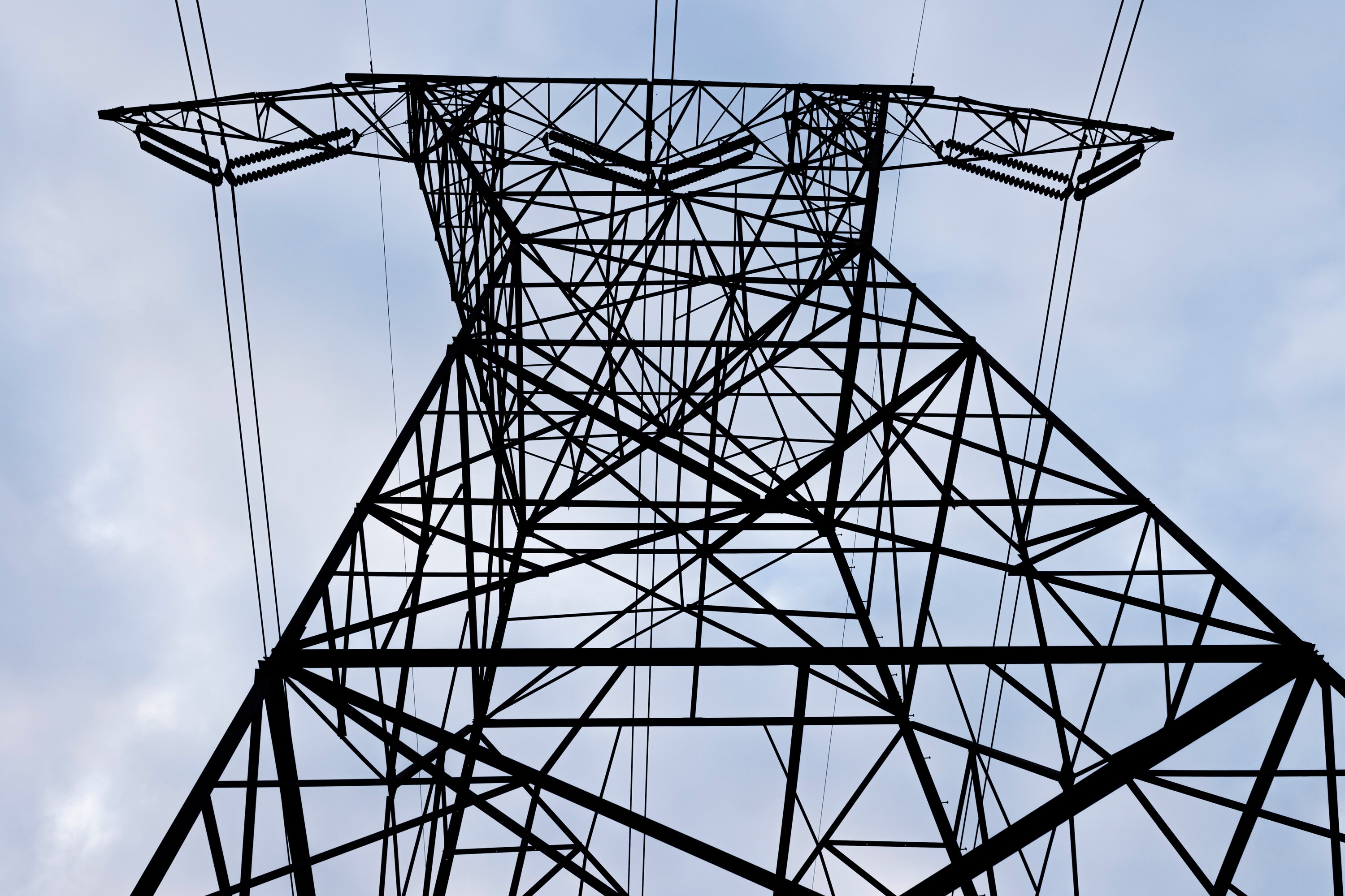 A transmission tower that is part of PJM Interconnection’s multistate system supports power lines that run high above farmland in Parkton.