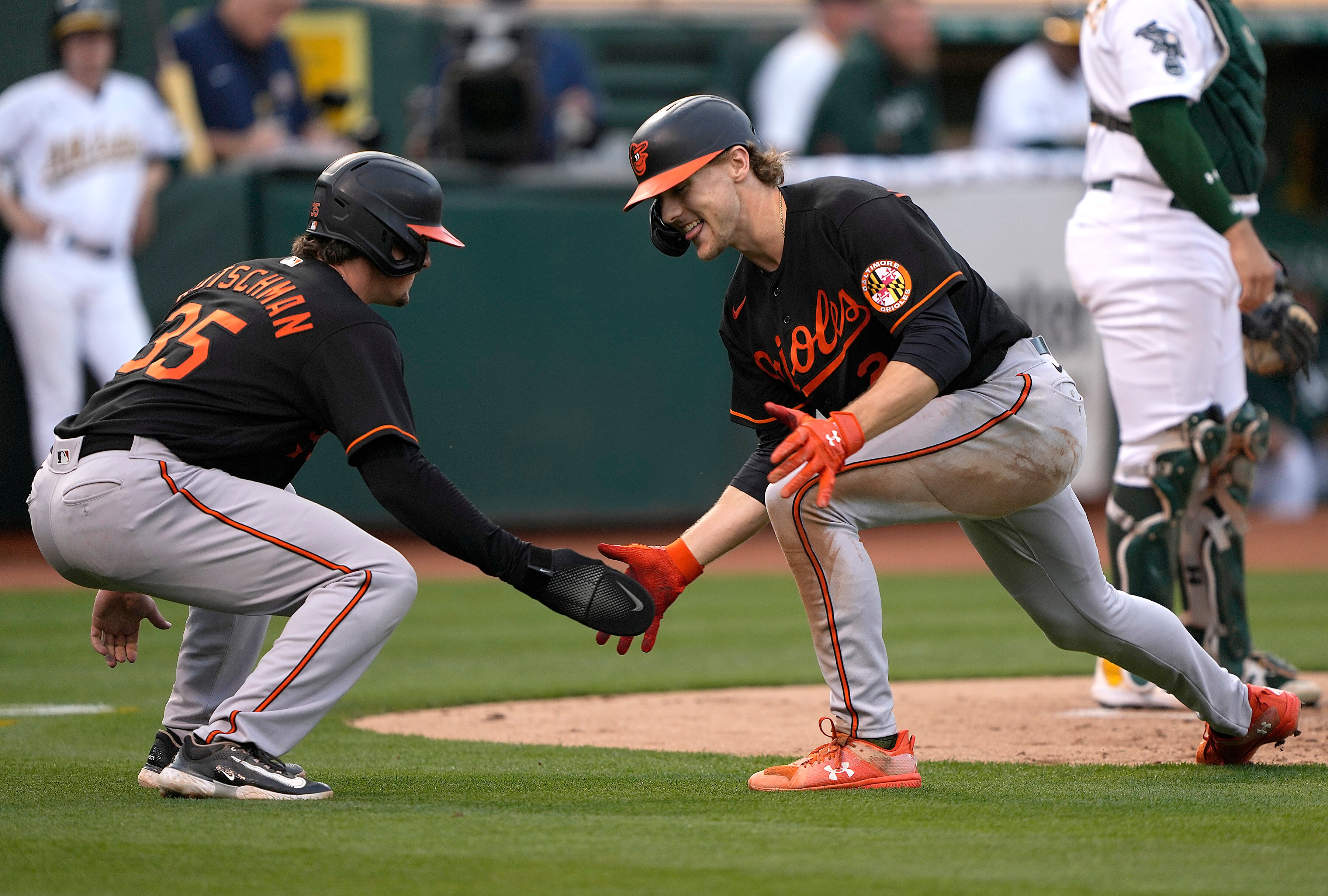 Gunnar Henderson, right, and Adley Rutschman low-five after Henderson hit a two-run home run against the Oakland Athletics in August.