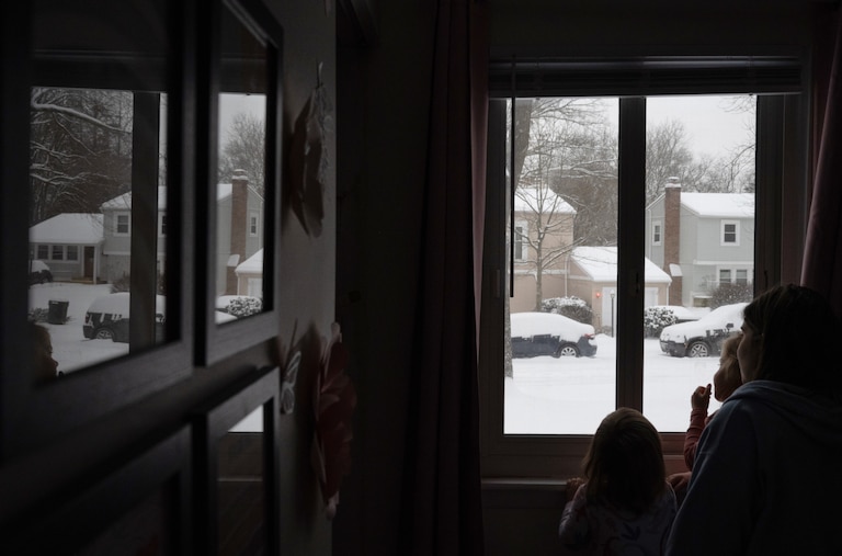 Mia (left, 1), Eva (center, 4) , and Anna (right) Thompson look out at the snowfall in their Columbia, MD neighborhood on January 6th, 2025.