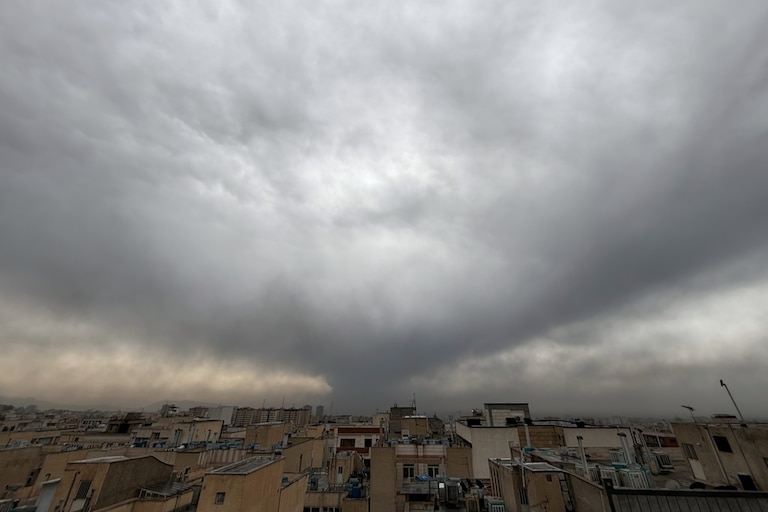 Plumes of smoke from a U.S.-Israeli strike on an oil facility late Saturday linger and merge with the cloudy sky over Tehran, Iran, Sunday, March 8, 2026. (AP Photo/Vahid Salemi)