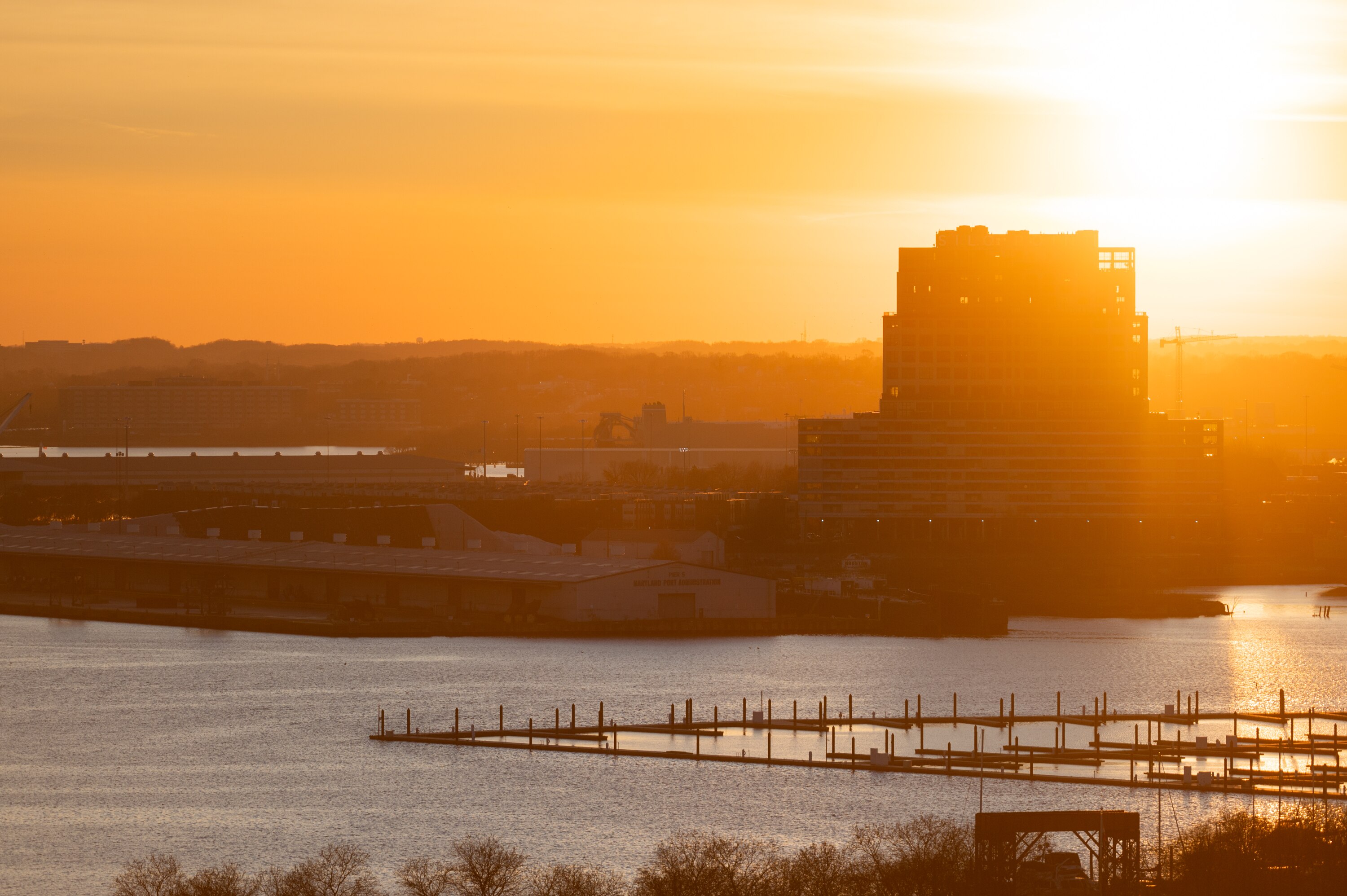 Sun sets over the harbor near Canton Waterfront Park