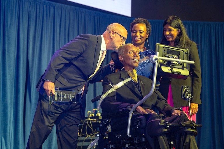 O.J. Brigance, seated, celebrates at a 2023 Brigance Brigade fundraiser with former board member Mike Gathagan, wife Chanda Brigance and Lt. Gov Aruna Miller. Brigance was a championship-winning linebacker for the Baltimore Ravens and Baltimore Stallions before becoming a prominent spokesman for ALS patients and their families. His foundation has raised millions in grant money for ALS patients to improve their quality of life.