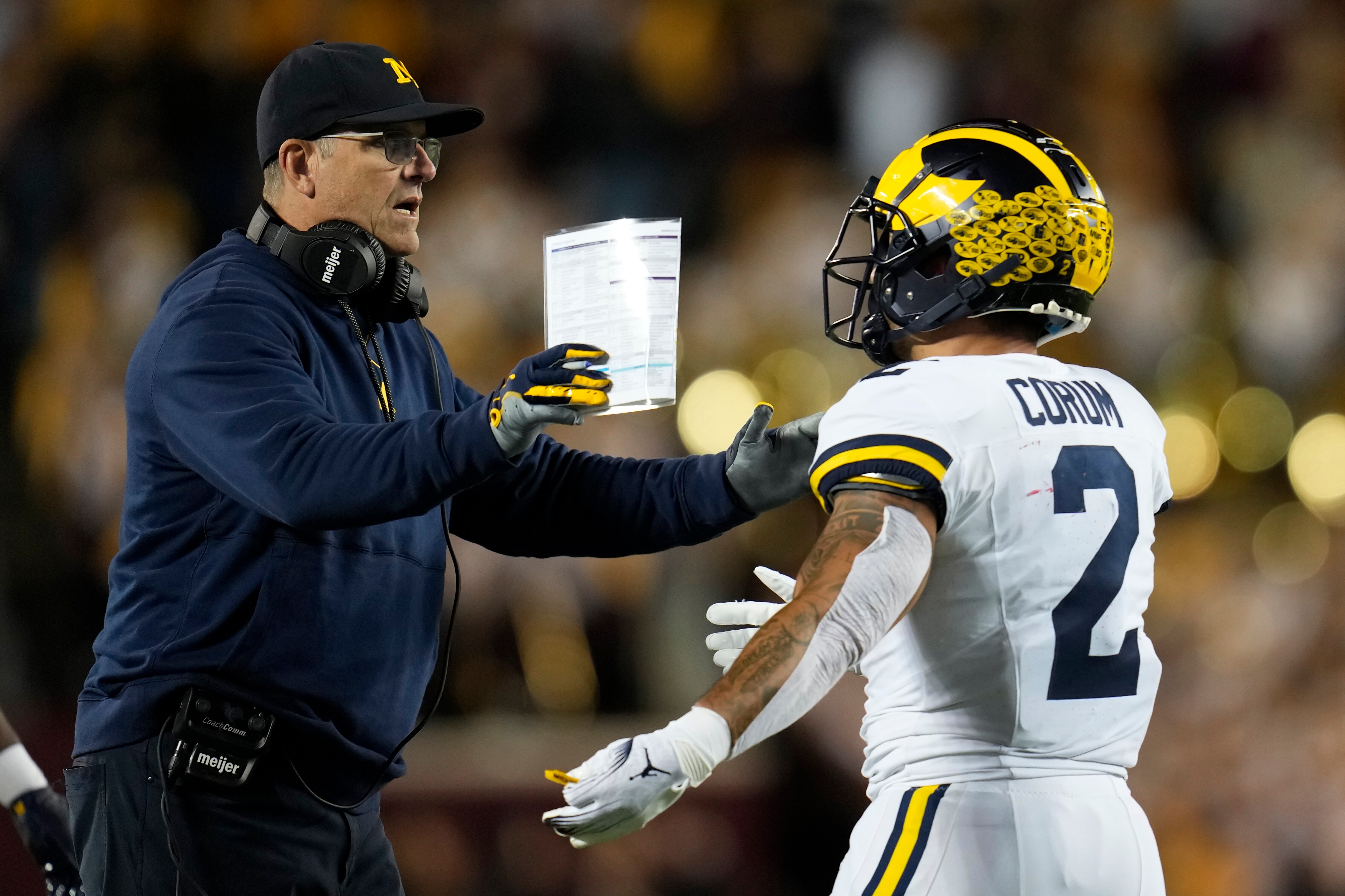 Michigan head coach Jim Harbaugh celebrates with running back Blake Corum, right, after scoring a touchdown during the first half of an NCAA college football game against Minnesota Saturday, Oct. 7, 2023, in Minneapolis.