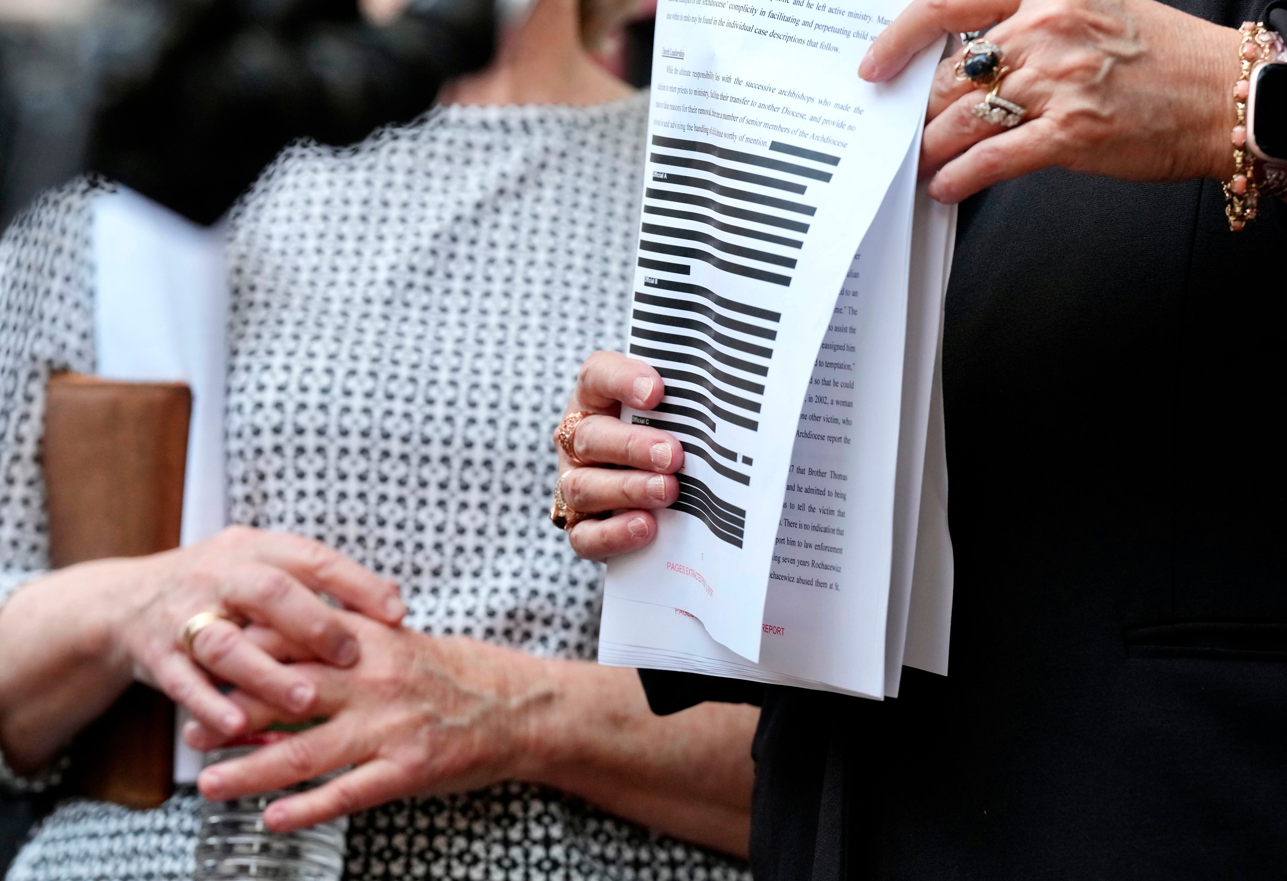 The Attorney General’s office released the Catholic Church Investigation papers.  Jean Hargadon (glasses) Teresa Lancaster,  holds a redacted copy of the release.