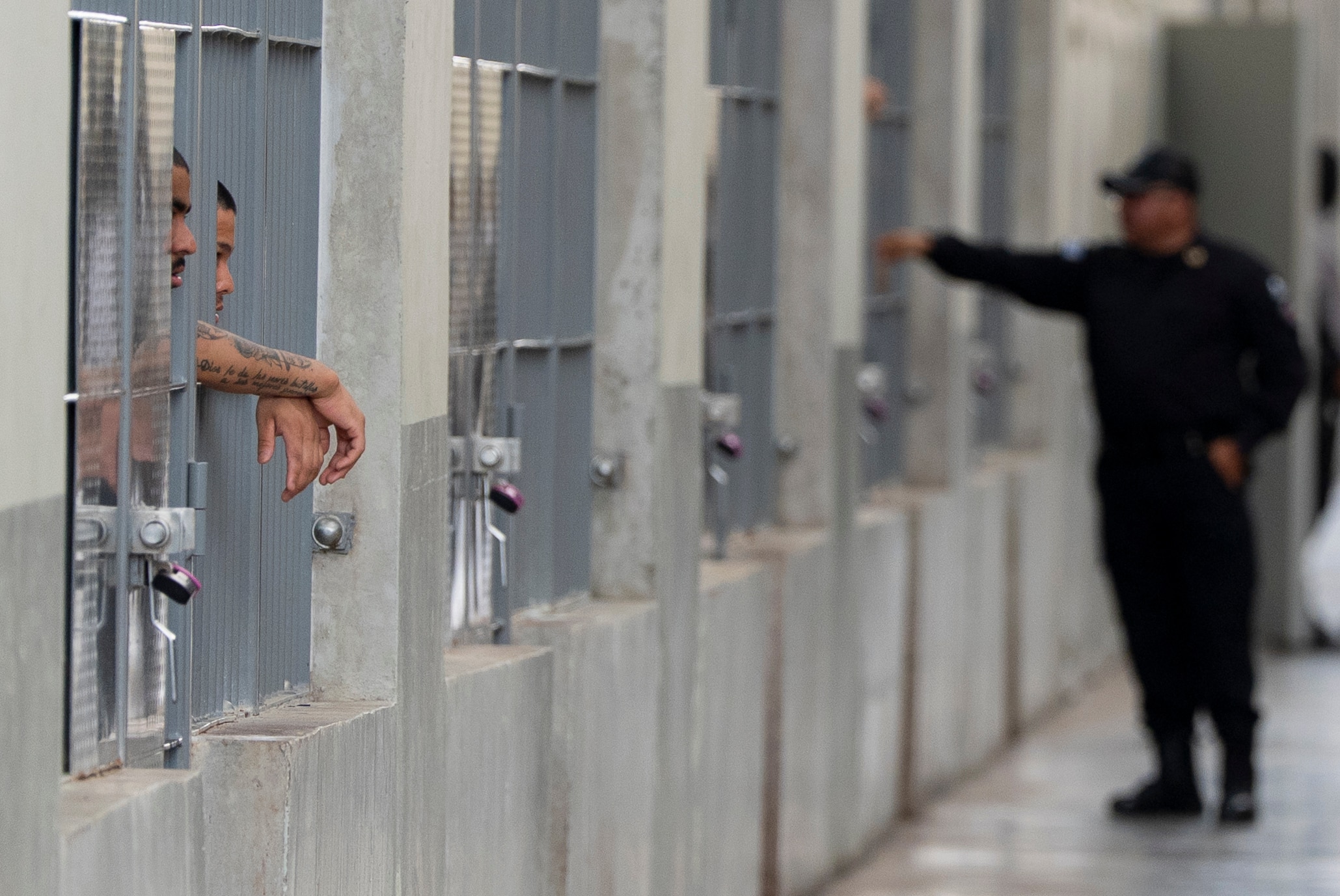 TECOLUCA, EL SALVADOR - MARCH 26: Prisoners look out their cell as Department of Homeland Security Secretary Kristi Noem tours the Terrorist Confinement Center (CECOT) on March 26, 2025 in Tecoluca, El Salvador. The Trump administration deported 238 alleged members of the Venezuelan criminal organizations 'Tren De Aragua' and Mara Salvatrucha with only 23 being members of the Mara. Nayib Bukele president of El Salvador announced that his government will receive the alleged members of the gang to be taken to CECOT.