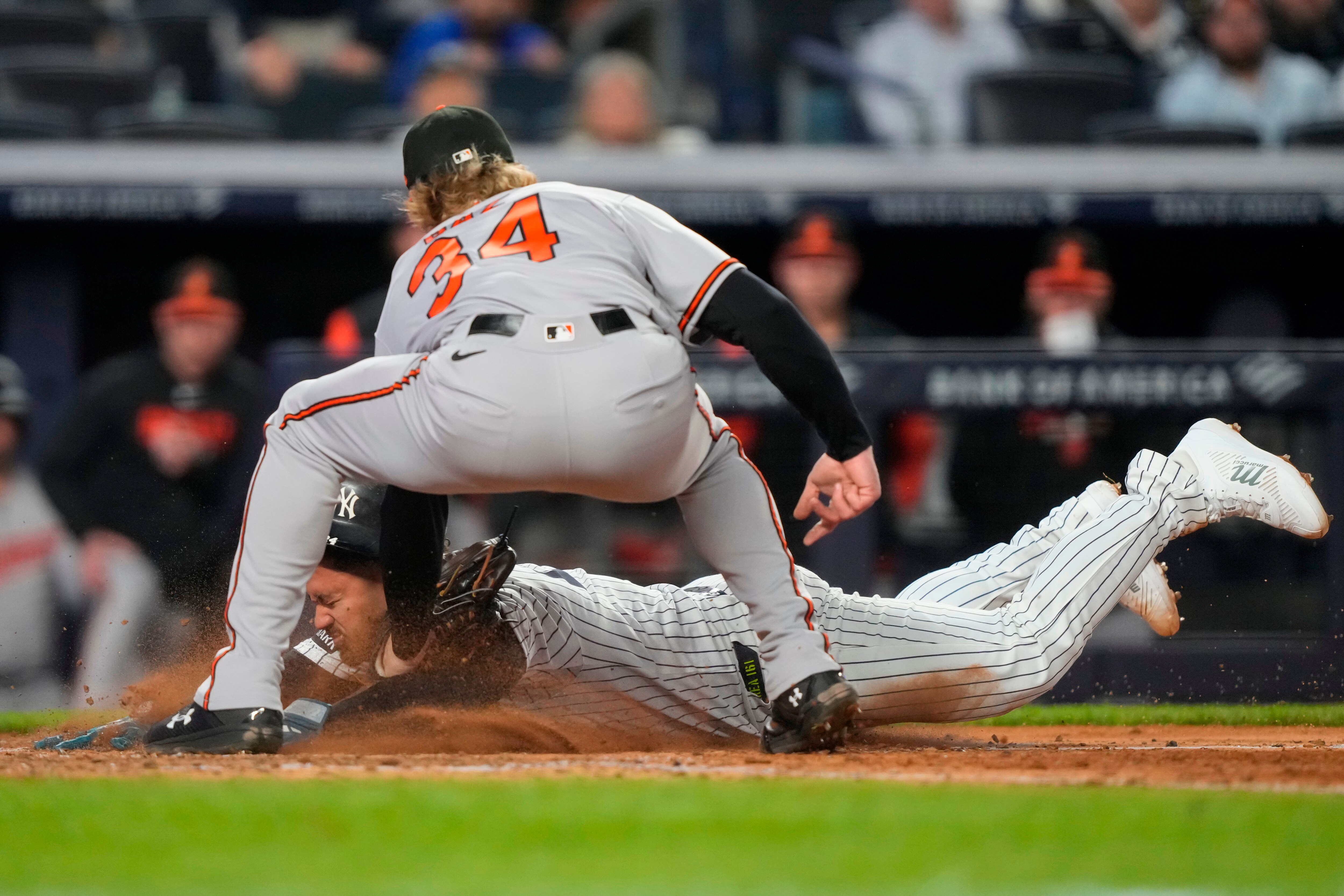 New York Yankees designated hitter Jasson Domínguez, bottom, successfully slides into home to score on a wild pitch by Orioles starting pitcher Shane Baz during the sixth inning.