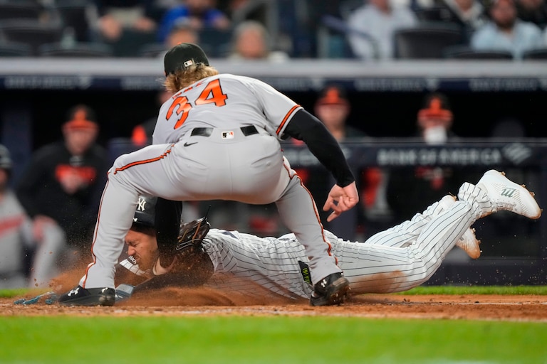 New York Yankees designated hitter Jasson Domínguez, bottom, successfully slides into home to score on a wild pitch by Orioles starting pitcher Shane Baz during the sixth inning.
