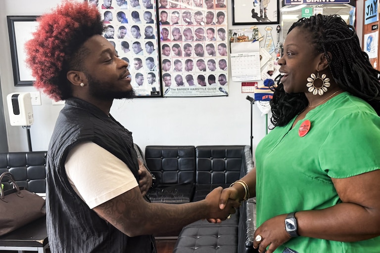 Montgomery County Board of Education candidate Elma-Lorraine Diggs shakes hands with barber Jayquan Jackson at Finesse Barbers and Stylists in Silver Spring.