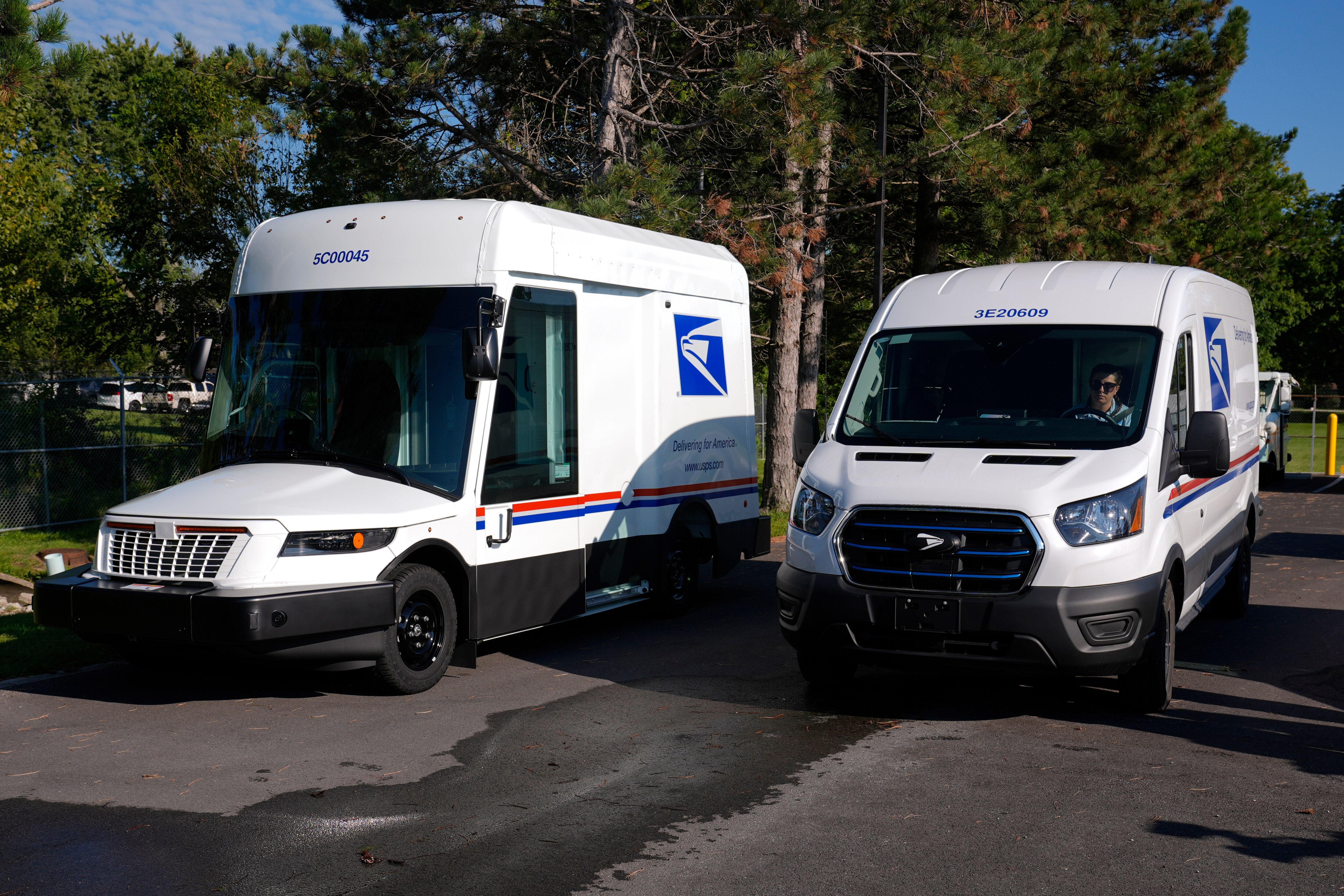 FILE - The U.S. Postal Service's next-generation delivery vehicle, left, is displayed as one new battery electric delivery trucks leaves the Kokomo Sorting and Delivery Center in Kokomo, Ind., Aug. 29, 2024. (AP Photo/Michael Conroy, File)