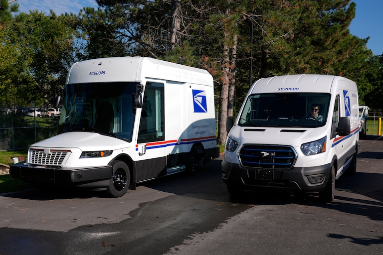 FILE - The U.S. Postal Service's next-generation delivery vehicle, left, is displayed as one new battery electric delivery trucks leaves the Kokomo Sorting and Delivery Center in Kokomo, Ind., Aug. 29, 2024. (AP Photo/Michael Conroy, File)