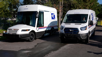 FILE - The U.S. Postal Service's next-generation delivery vehicle, left, is displayed as one new battery electric delivery trucks leaves the Kokomo Sorting and Delivery Center in Kokomo, Ind., Aug. 29, 2024. (AP Photo/Michael Conroy, File)