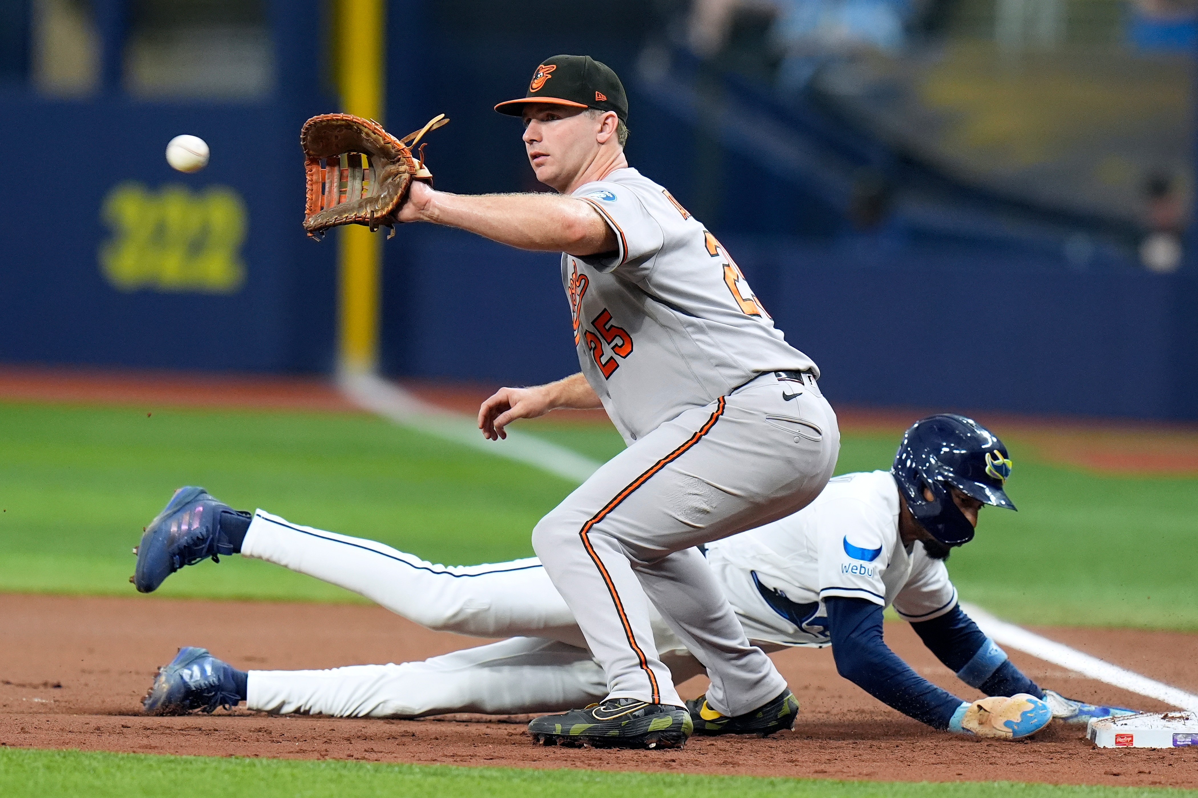 Tampa Bay Rays' Chandler Simpson dives back safely to first ahead of the pickoff throw to Baltimore Orioles' Pete Alonso (25) during the first inning of a baseball game Friday, Aug. 14, 2026, in St. Petersburg, Fla.