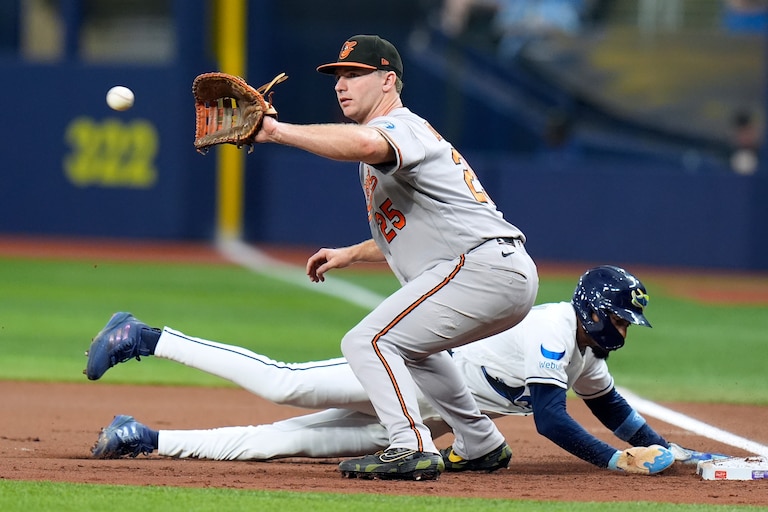 Tampa Bay Rays' Chandler Simpson dives back safely to first ahead of the pickoff throw to Baltimore Orioles' Pete Alonso (25) during the first inning of a baseball game Friday, Aug. 14, 2026, in St. Petersburg, Fla.