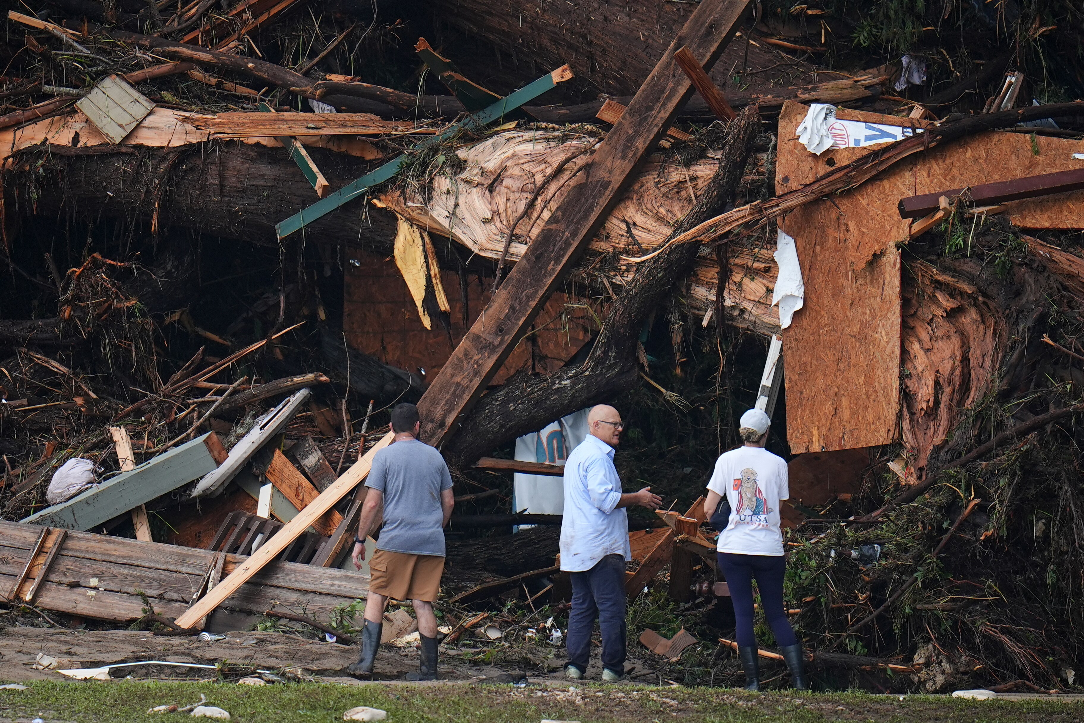 People look at debris on the banks of the Guadalupe River after a flash flood swept through the area Saturday, July 5, 2025, in Hunt, Texas.