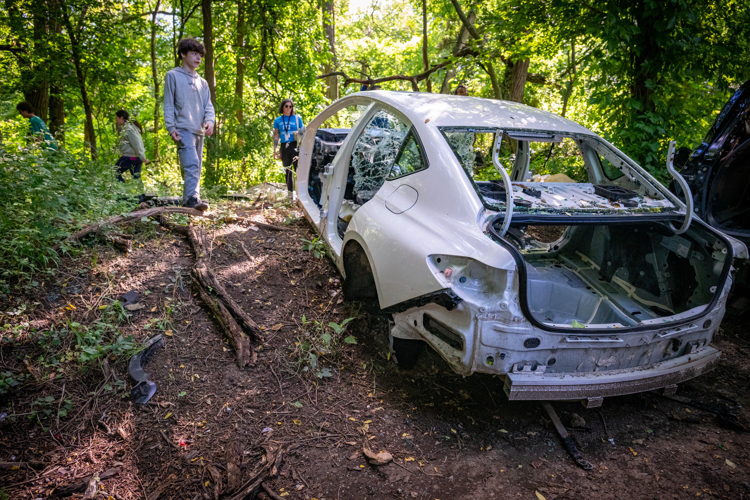 Students with teacher Katlyn Talerico’s hiking group from Armistead Gardens Elementary/Middle School come across an abandoned car  along the trail at lower Herring Run Park.