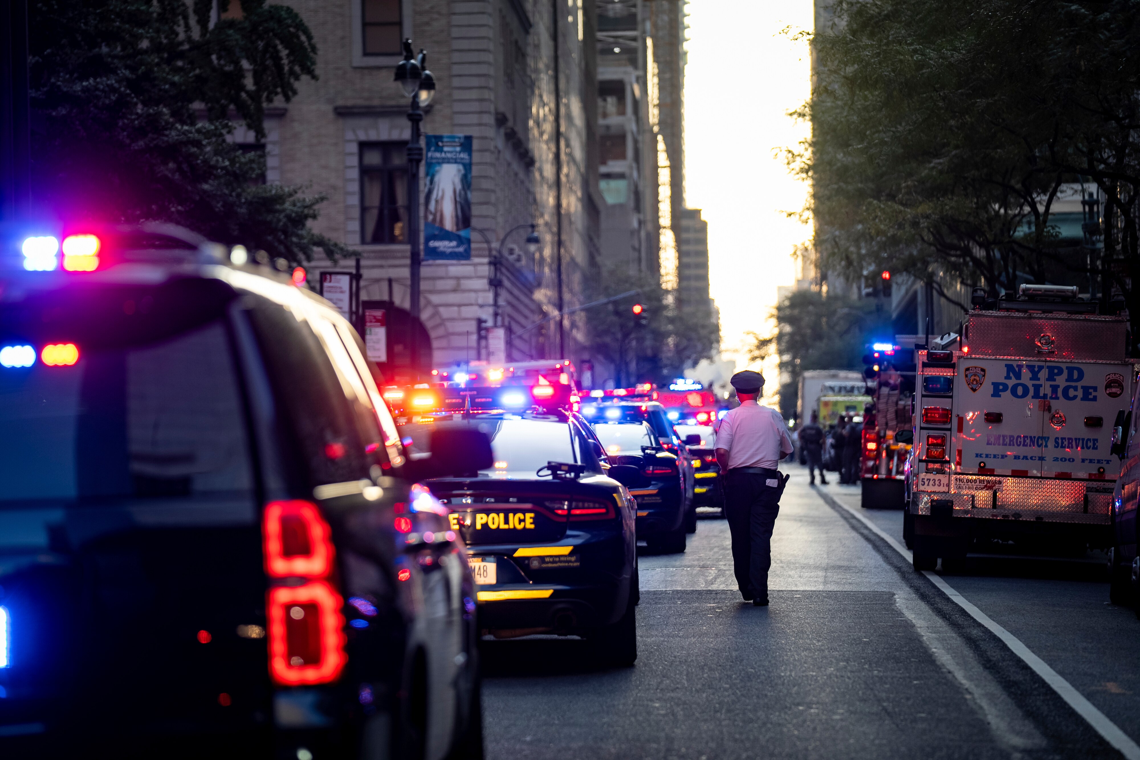 A New York police officer stands watch on 52nd Street outside a Manhattan office building where at least two people were shot, including a police officer, Monday, July 28, 2025, in New York.