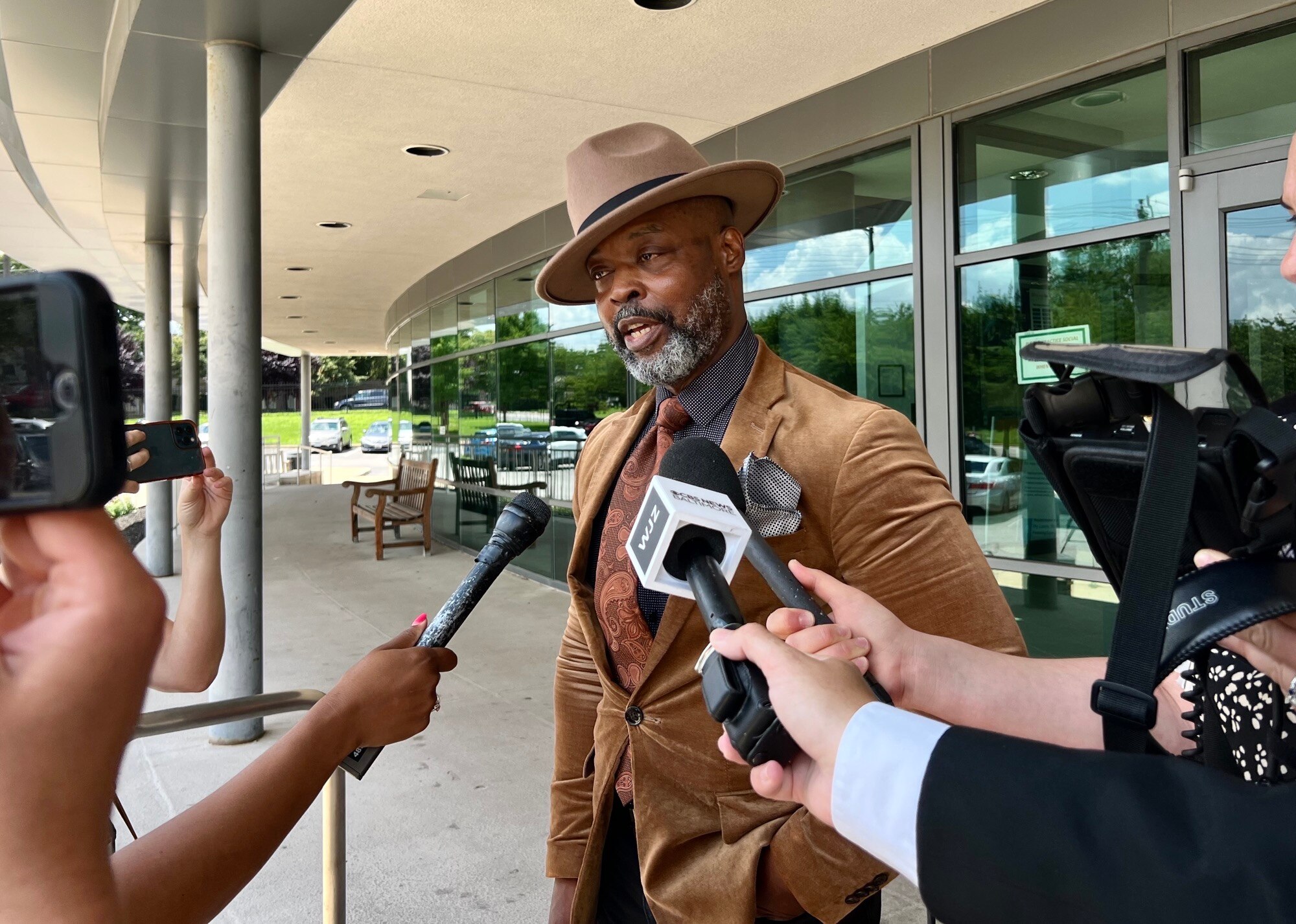 Michael Clinkscale, center, speaks to reporters on Monday outside the John R. Hargrove Sr. District Court Building in Baltimore after a judge held his client without bond. Clinkscale represents a 17-year-old who’s facing weapons charges related to the investigation into the mass shooting that happened at a block party in Brooklyn.