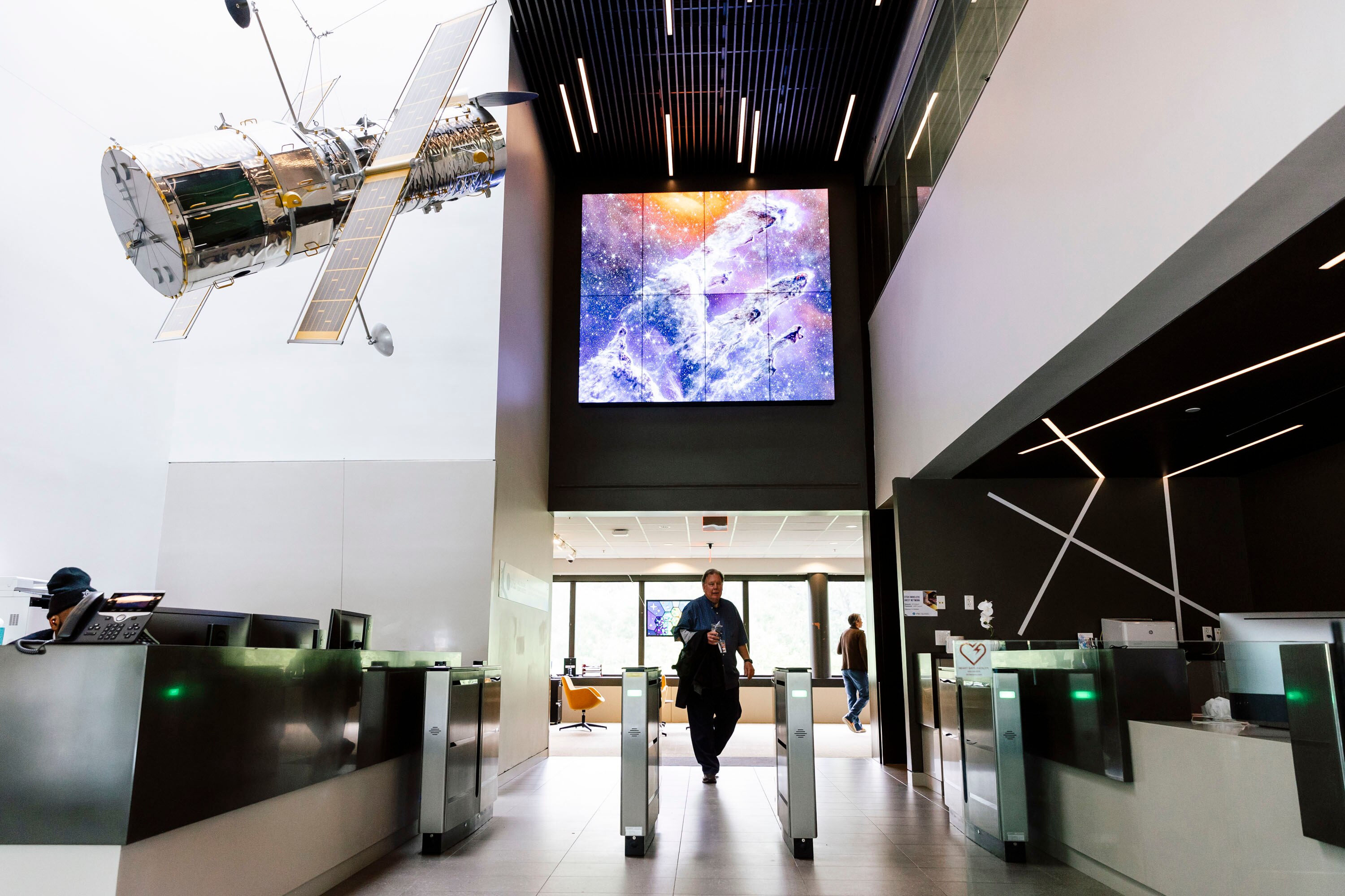 A monitor showing a photo of the “Pillars of Creation,” captured by the James Webb Space Telescope, hangs over the front lobby of the Space Telescope Science Institute on the Johns Hopkins University Homewood campus on May 15, 2024.