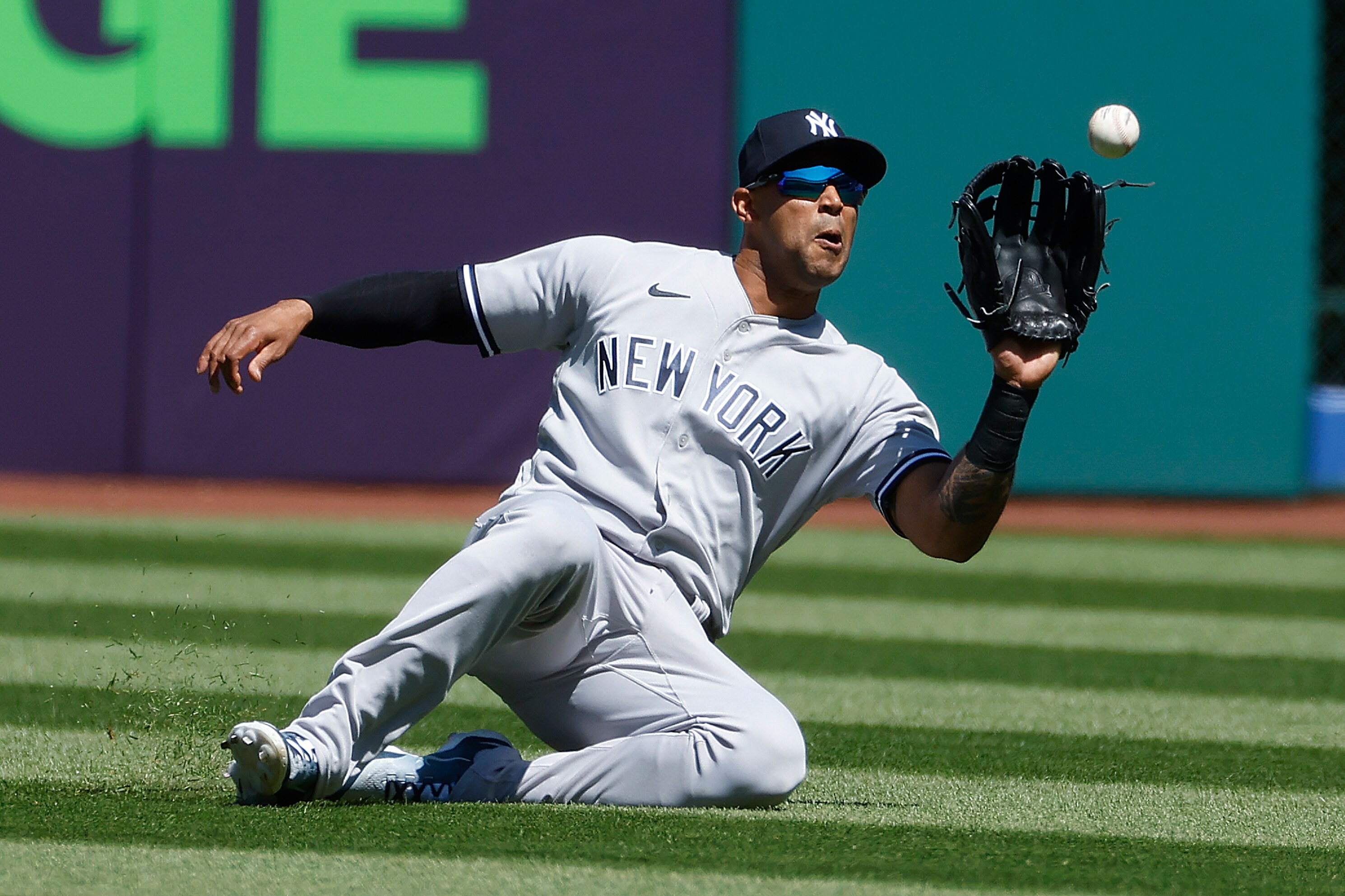 Aaron Hicks #31 of the New York Yankees makes a sliding catch to get out Amed Rosario #1 of the Cleveland Guardians during the first inning at Progressive Field on April 12, 2023 in Cleveland, Ohio.