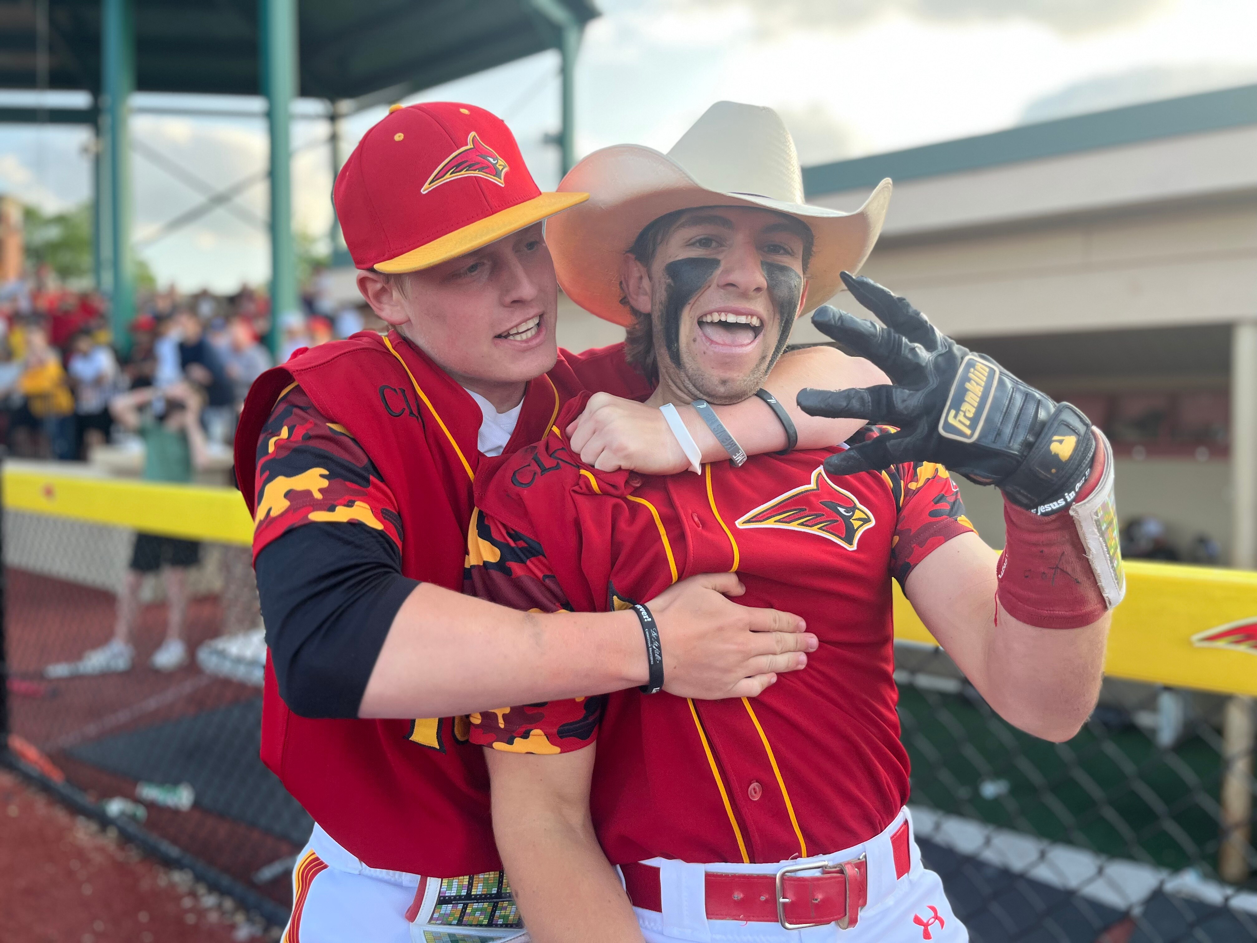Calvert Hall's Jake Butler (with hat) is grabbed by a teammate after his grandslam homerun in the bottom of the seventh Friday afternoon. Butler's shot gave the Cardinals a 4-3 victory over John Carroll in the MIAA A Conference Tournament's loser bracket final and a spot in Sunday's championship round.