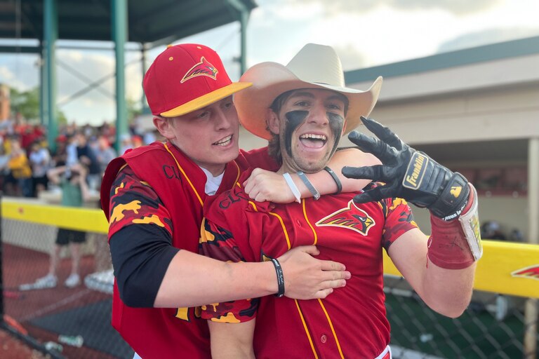 Calvert Hall's Jake Butler (with hat) is grabbed by a teammate after his grandslam homerun in the bottom of the seventh Friday afternoon. Butler's shot gave the Cardinals a 4-3 victory over John Carroll in the MIAA A Conference Tournament's loser bracket final and a spot in Sunday's championship round.