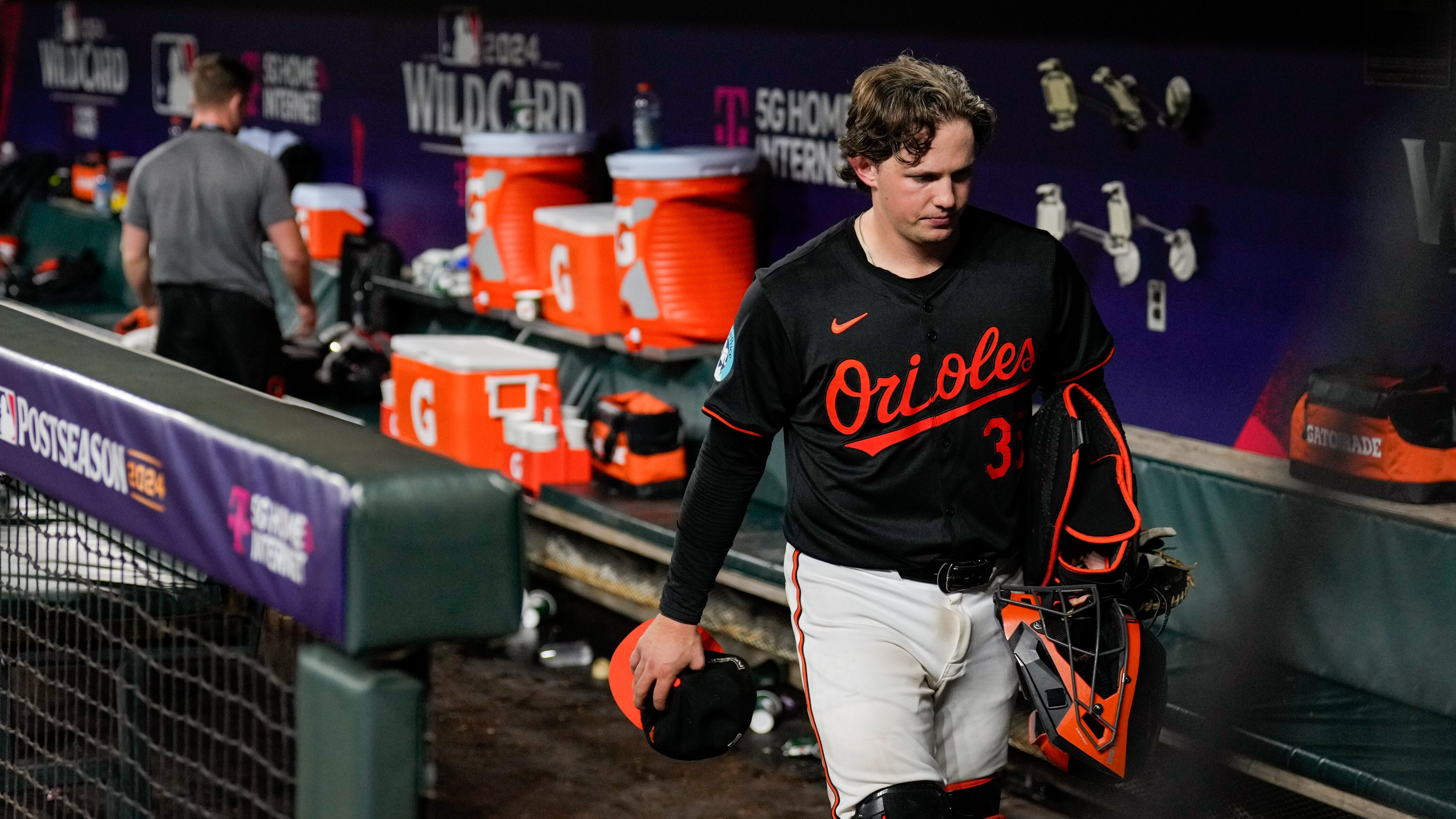Baltimore Orioles catcher Adley Rutschman (35) leaves the dugout as the Kansas City Royals celebrate on the field after advancing past them in the Wild Card series at Camden Yards in Baltimore on Wednesday, October 2, 2024.