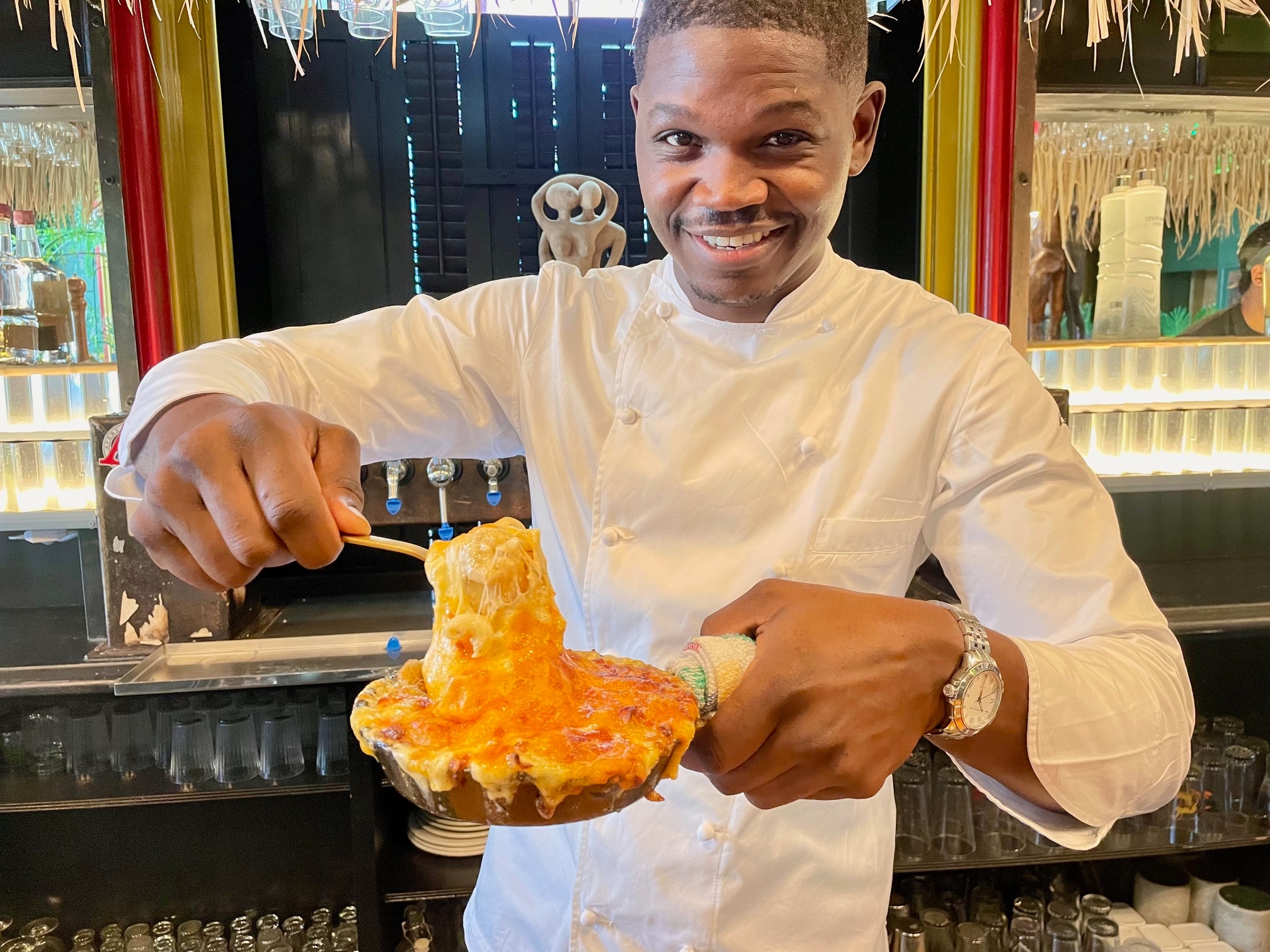 Loic Sany, chef and partner at Jerk at Nite, poses with his restaurant's macaroni and cheese.