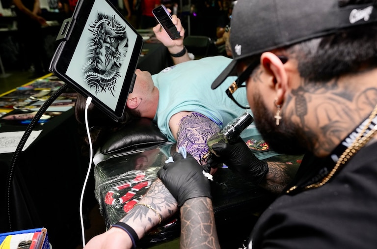 Diego Orbegozo from Black Label Collective tattoos Karl Staudinger at the Baltimore Tattoo Convention on April 21, 2023.