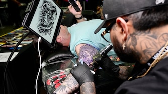 Diego Orbegozo from Black Label Collective tattoos Karl Staudinger at the Baltimore Tattoo Convention on April 21, 2023.