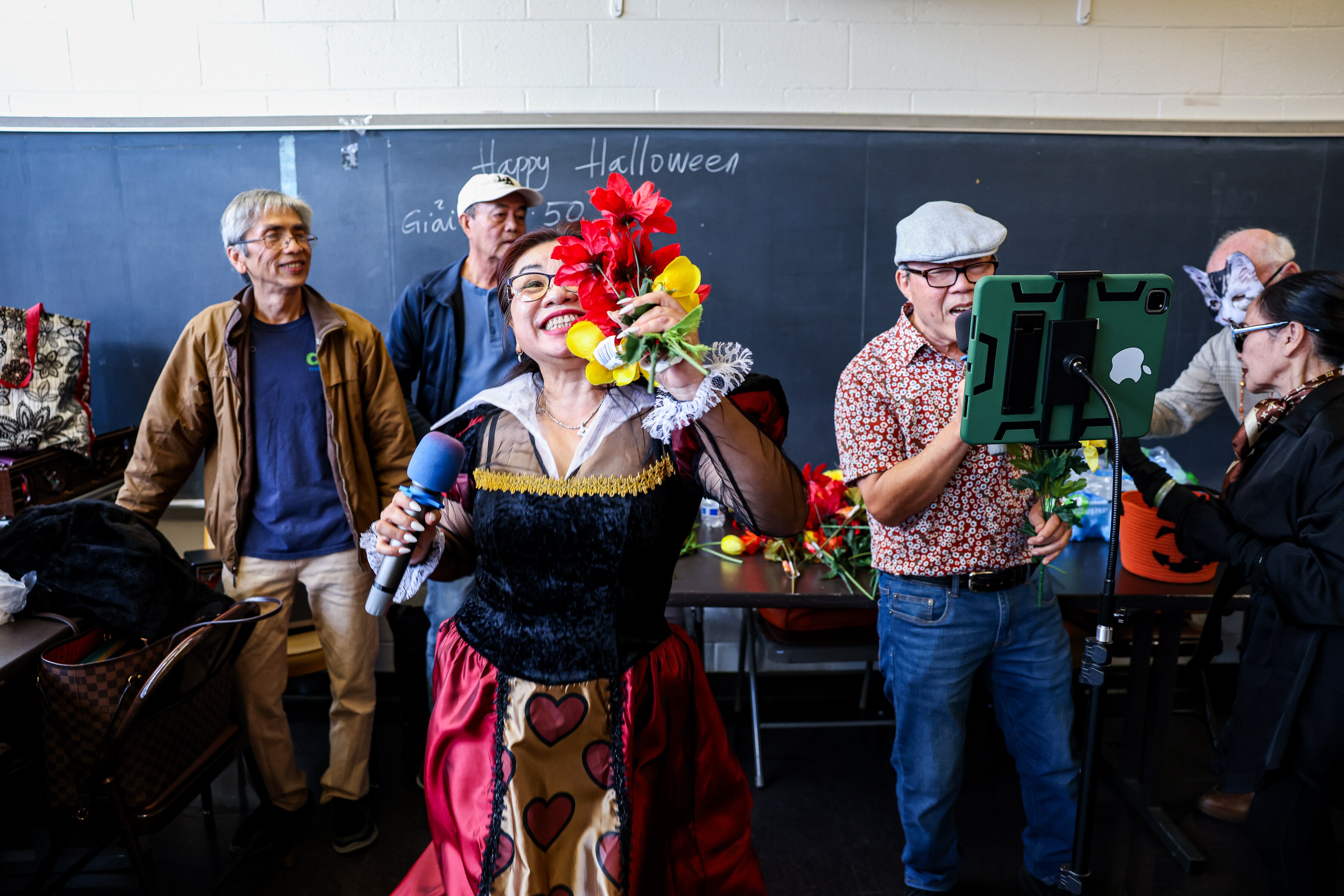 Host Quyen Duong, left, sings with other members of the Love Vietnamese Seniors Club at the Holiday Park Senior Center on Halloween.